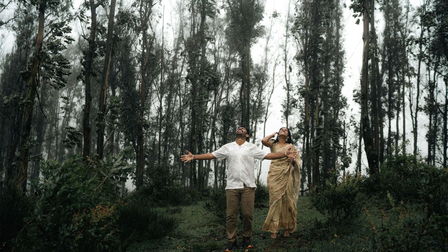 Playful poses in a eucalyptus forest with outstretched arms.