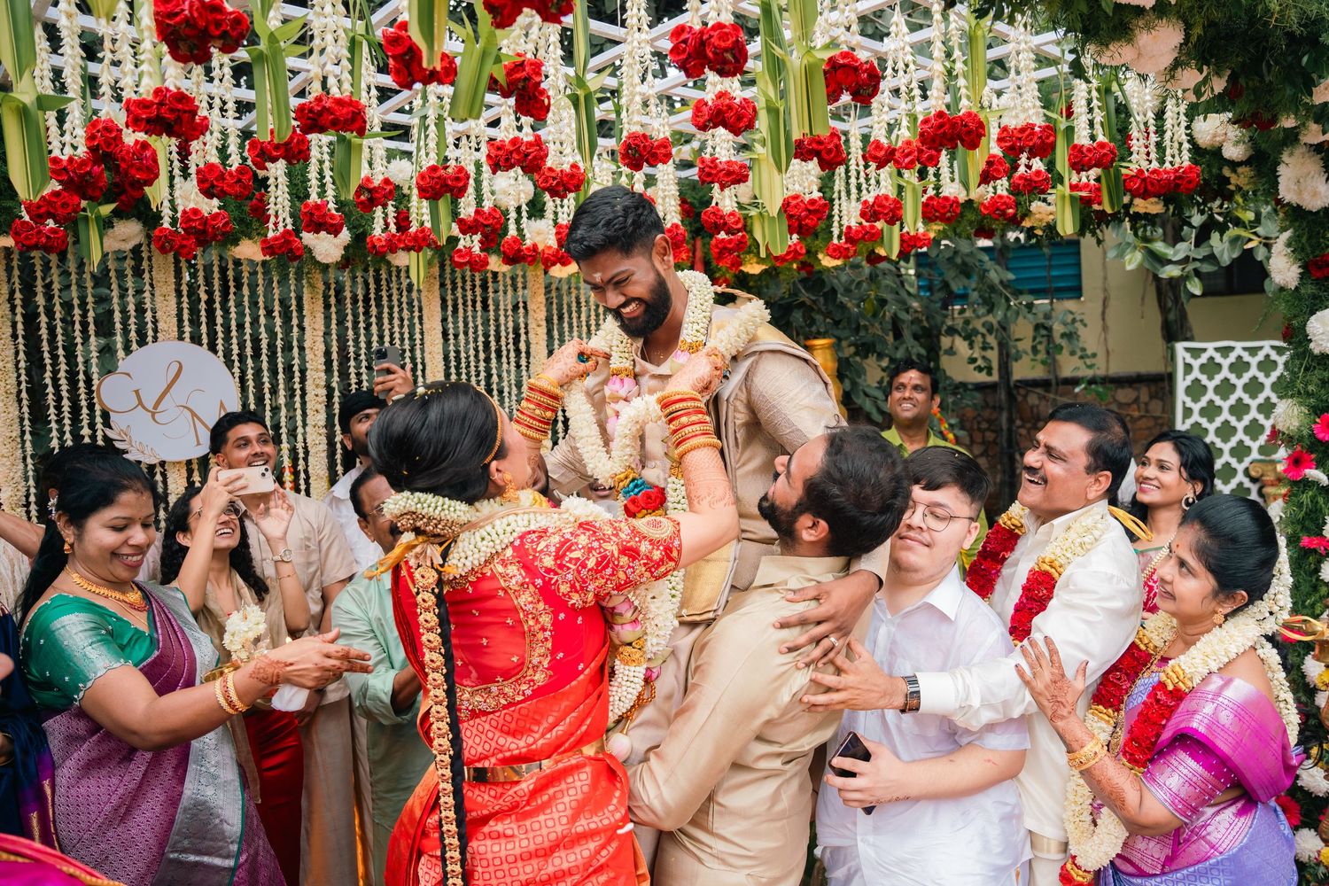 A collage of joyful Indian wedding moments shows celebrations with red garments and traditional customs under hanging red decor.
