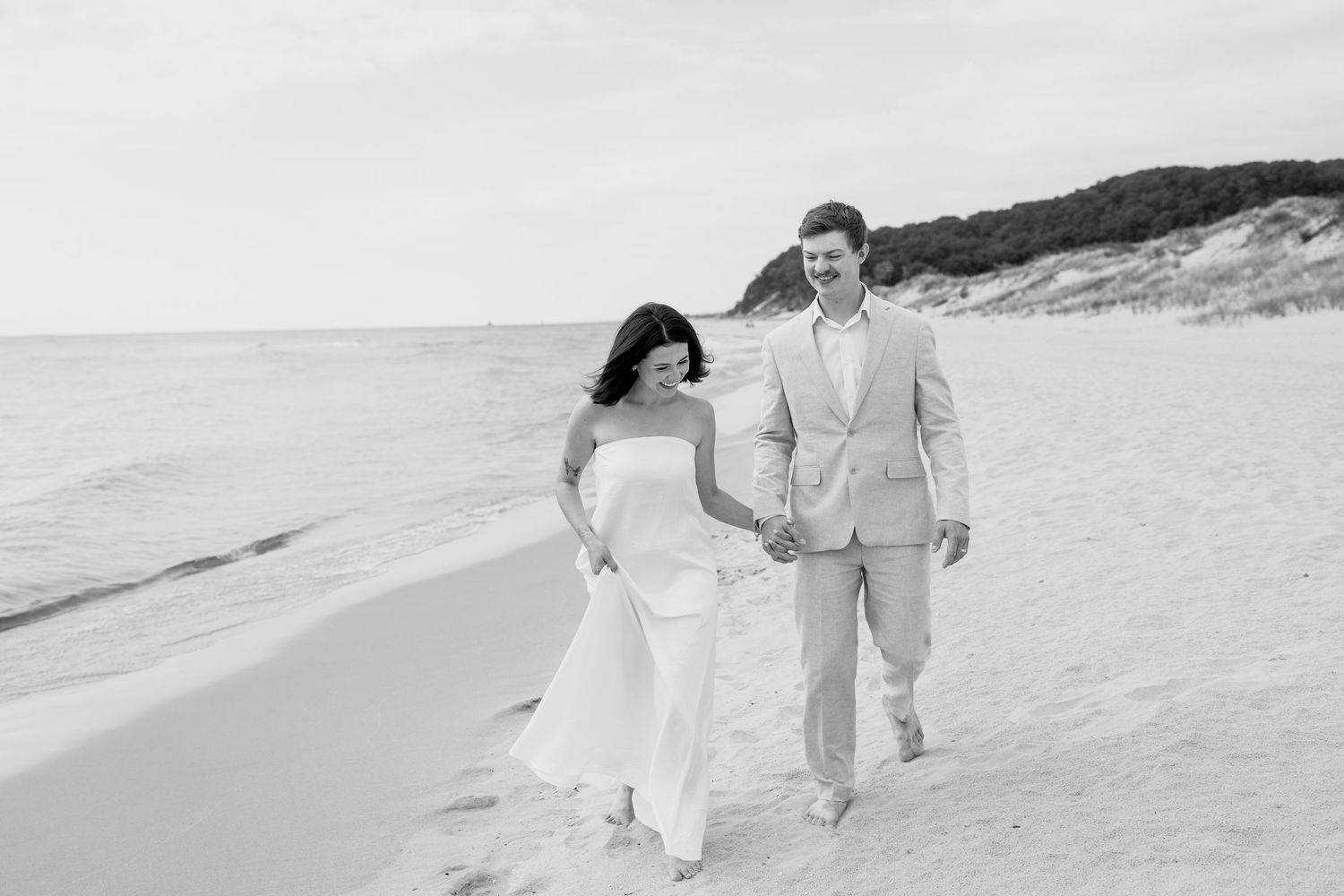 Artistic beach photography showing a couple strolling on white sand near the ocean.