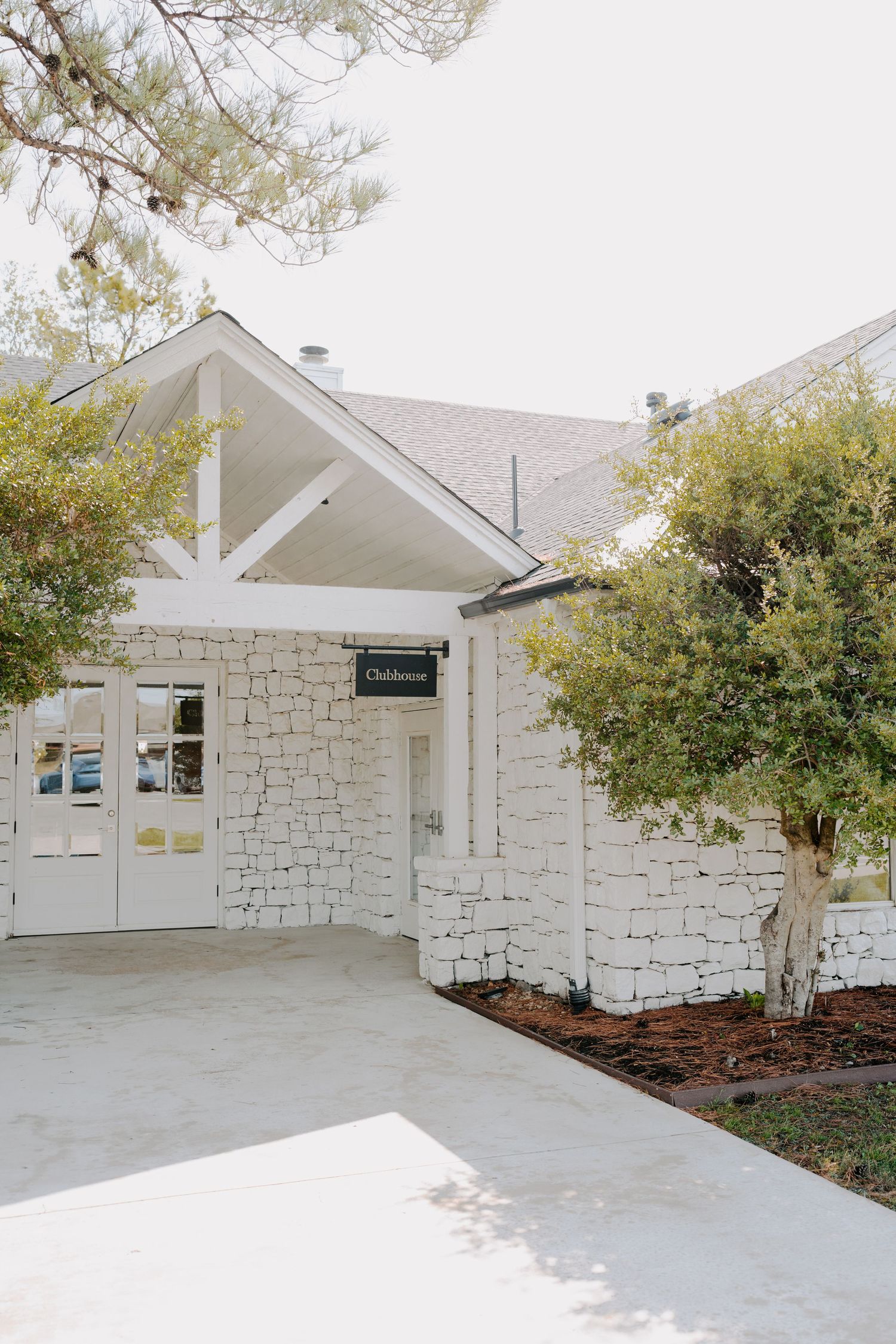 Modern white stone building exterior with clean architectural lines and landscaping.