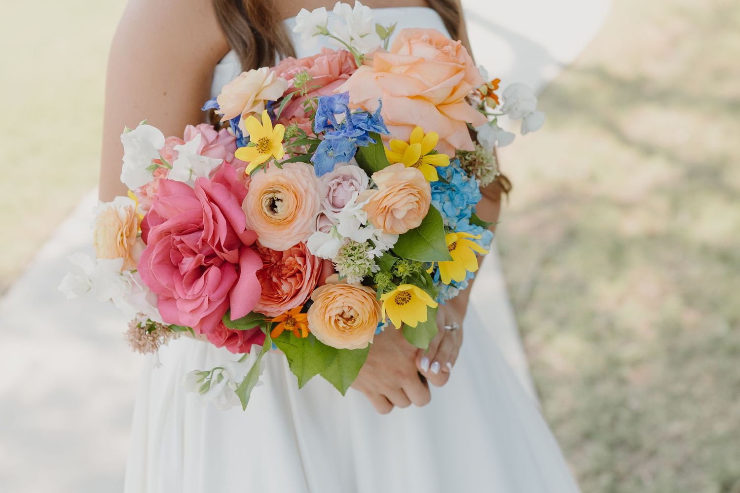 Colorful spring wedding bouquet with pink, yellow and peach blooms.