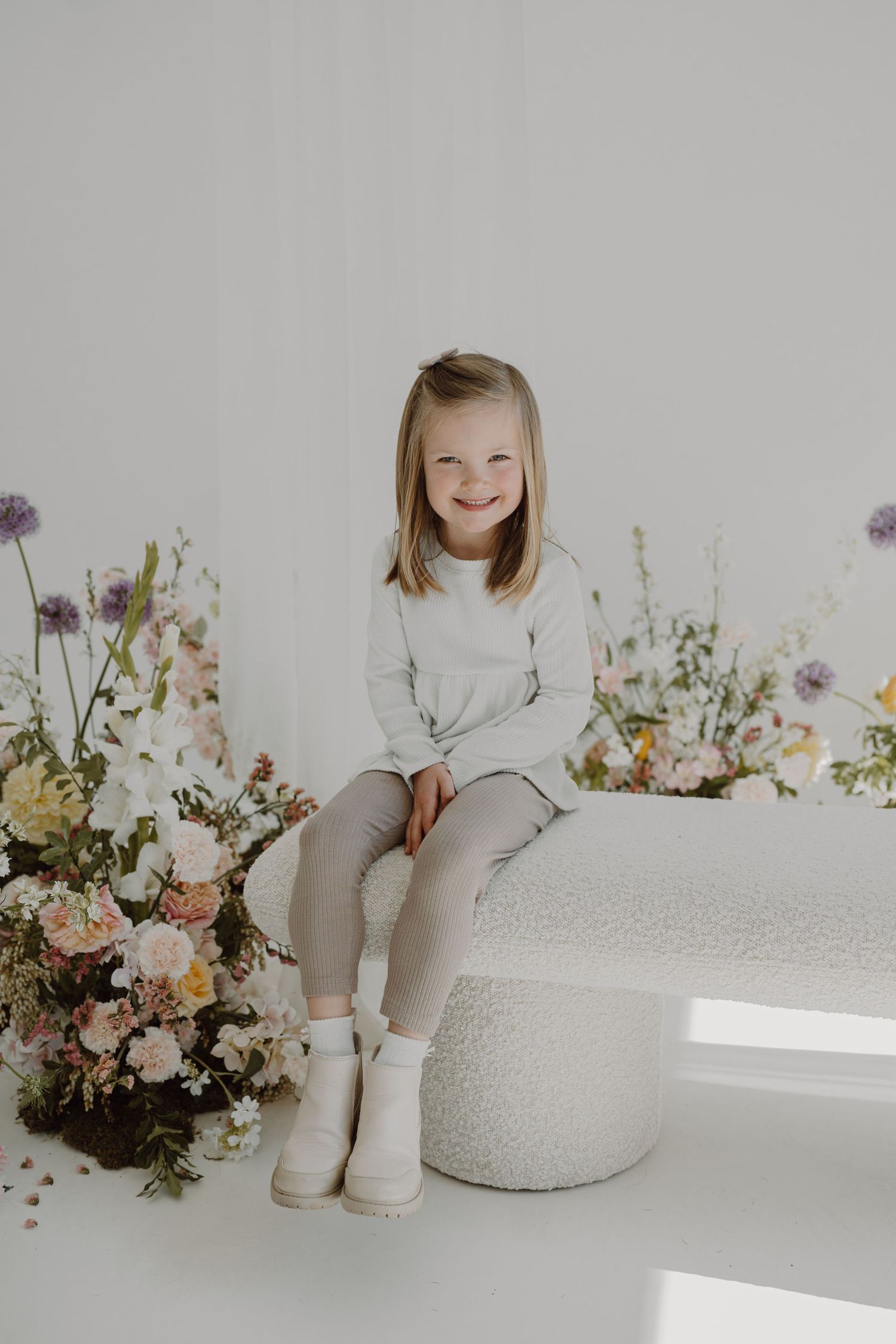 Studio portrait with soft lighting and romantic floral decorations.