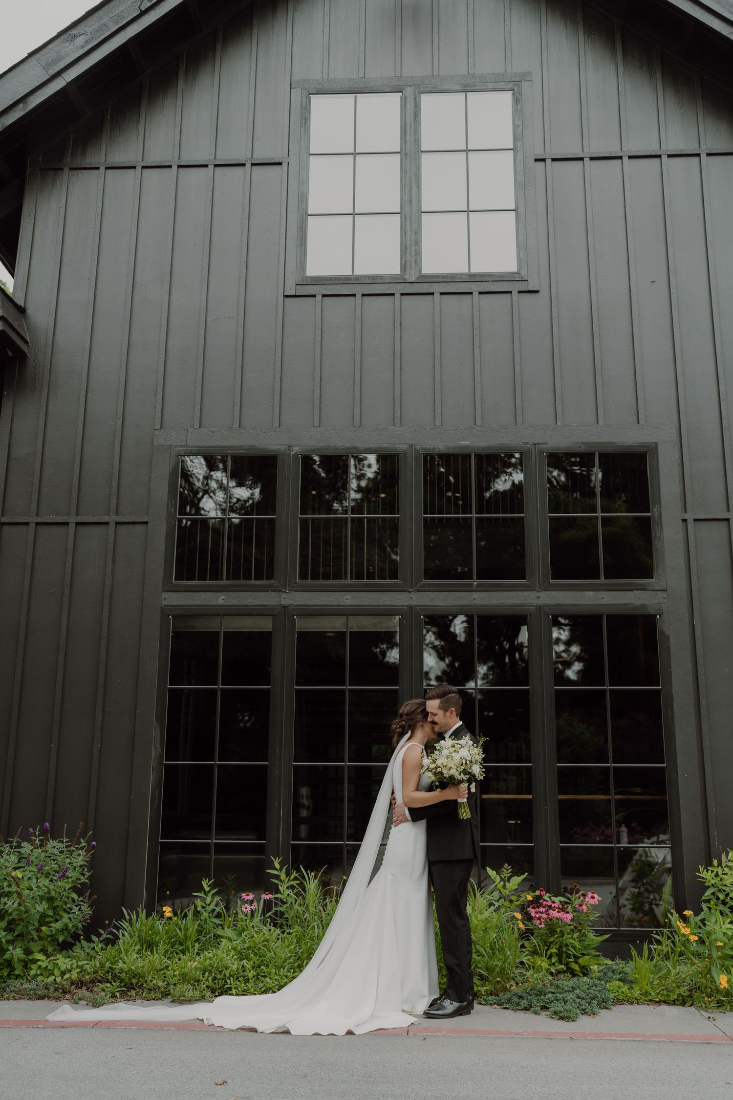 The minimalist black barn wedding venue Spain Ranch features striking vertical lines and glass panels.