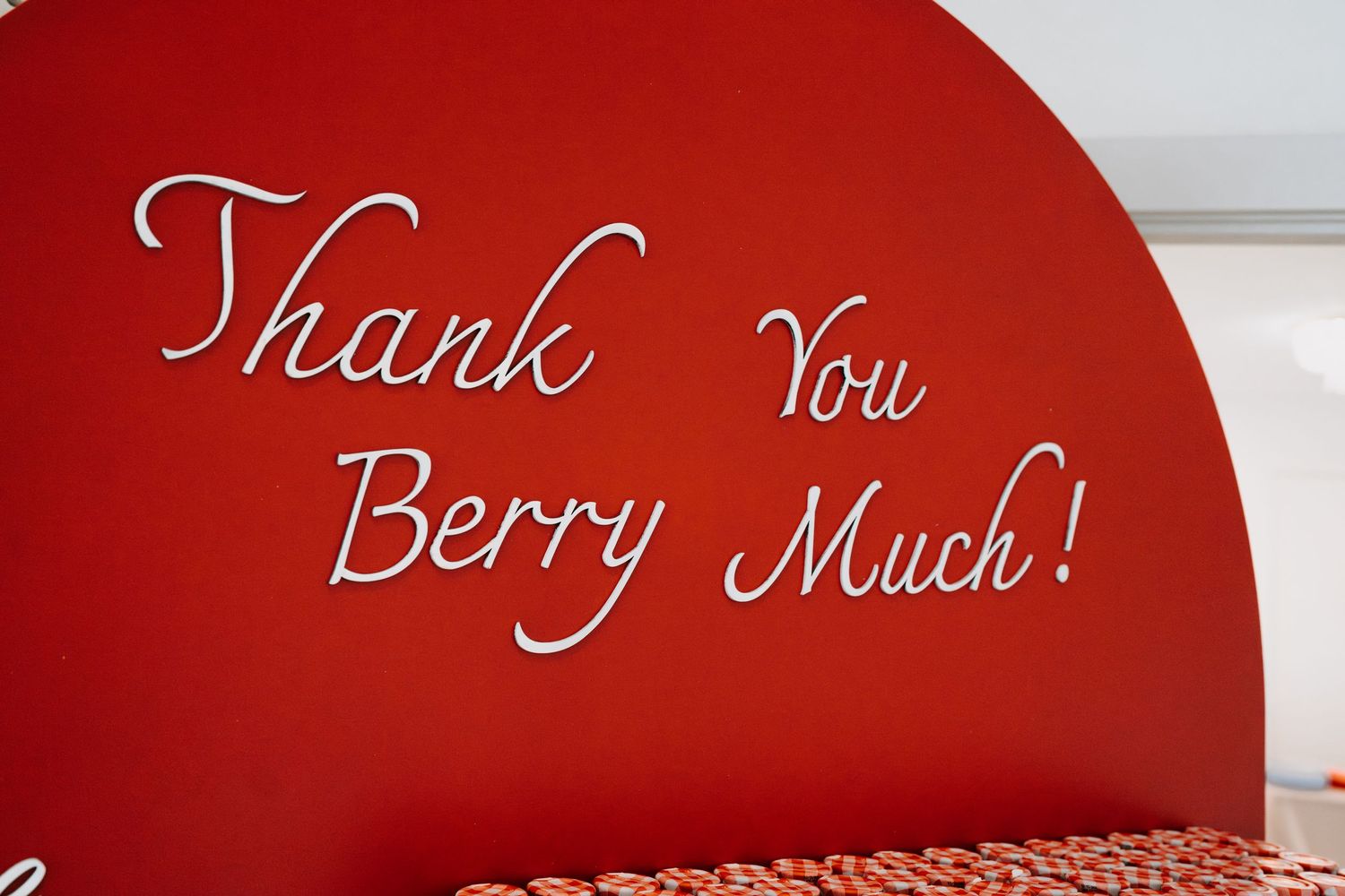 Curved red wall with elegant white script text reading 'Thank You'.