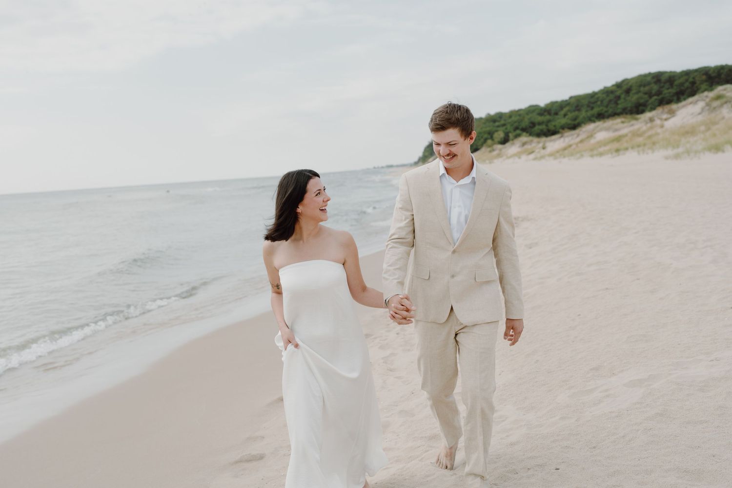 Couple in coordinated outfits walking together on a pristine beach landscape.