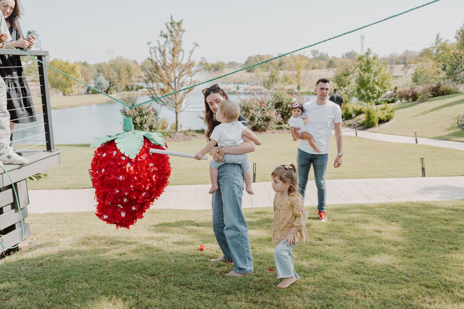 Outdoor scene with people and a bright red heart-shaped balloon display in the distance.