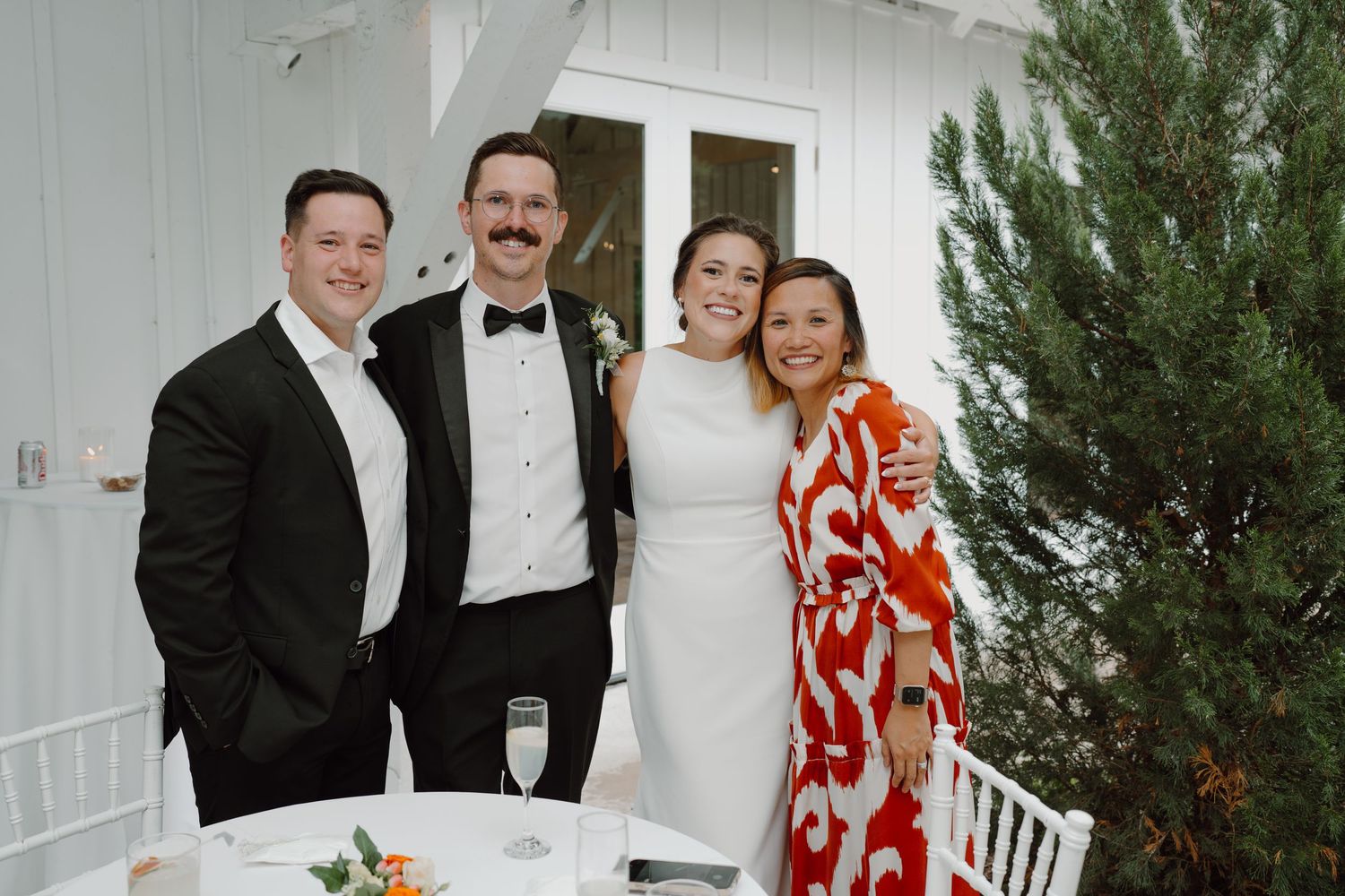 Group photo of wedding guests on a white porch during a celebration.