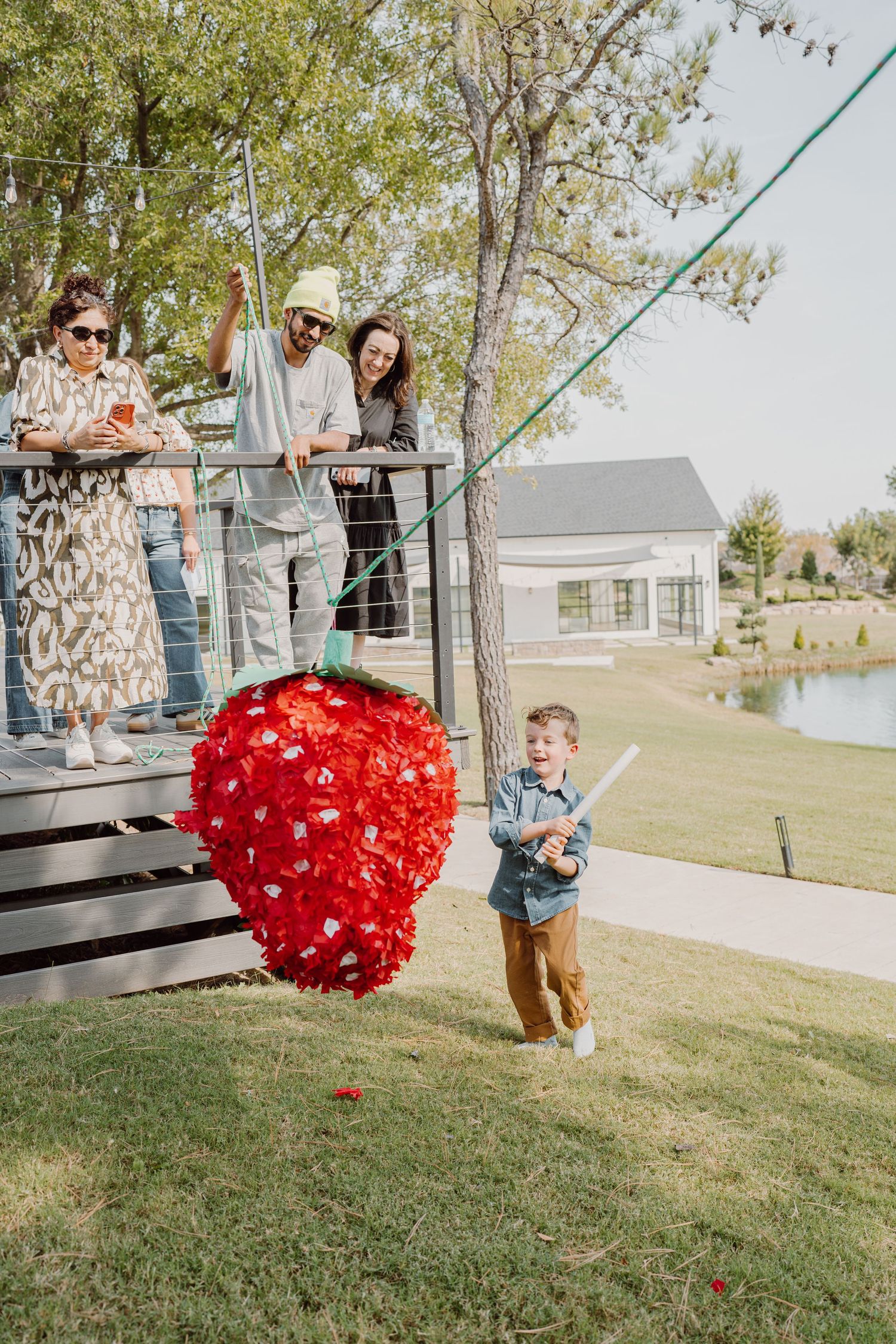 A red heart decoration swings through the air in a playful outdoor scene.