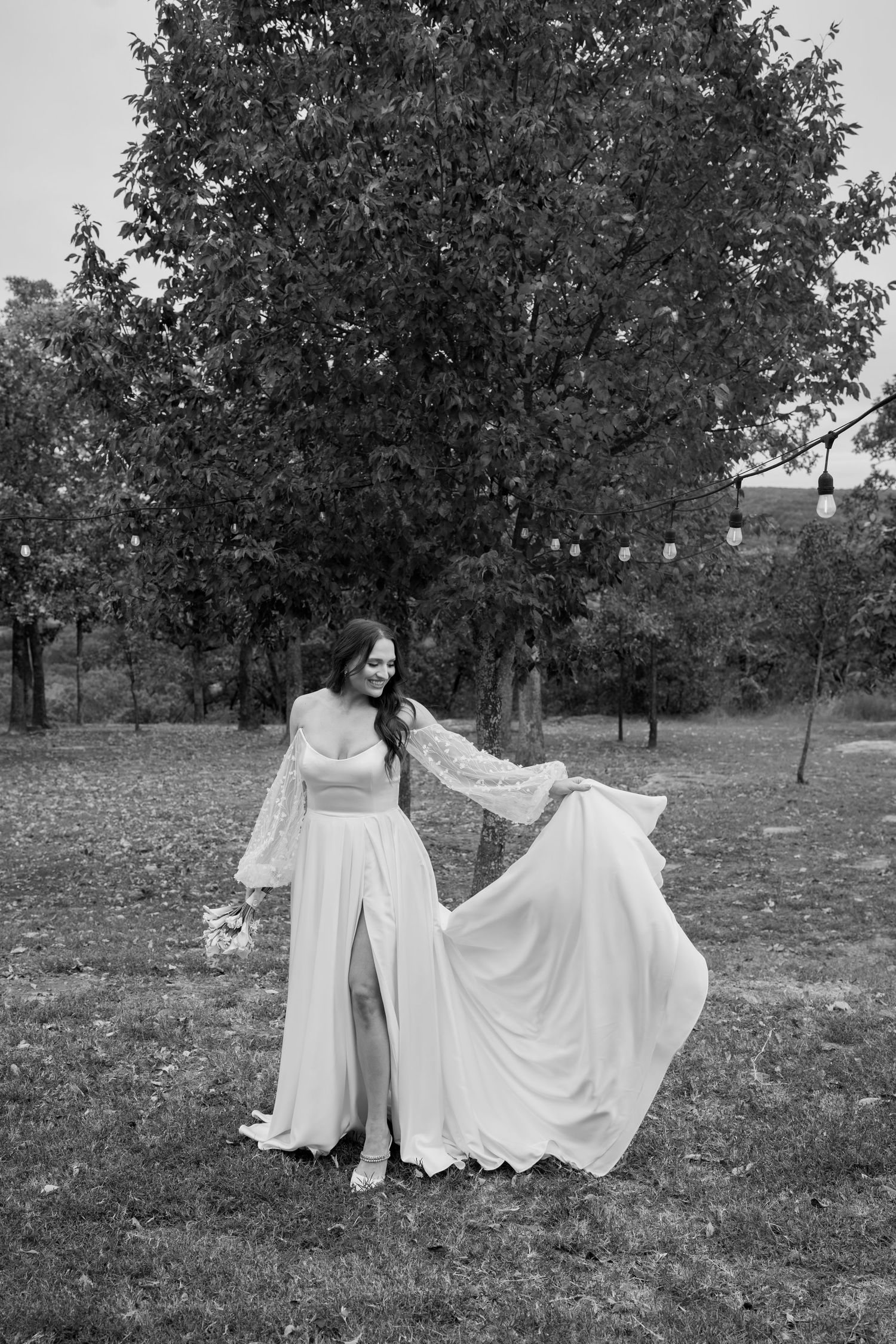 Black and white capture of flowing wedding dresses in an outdoor setting.