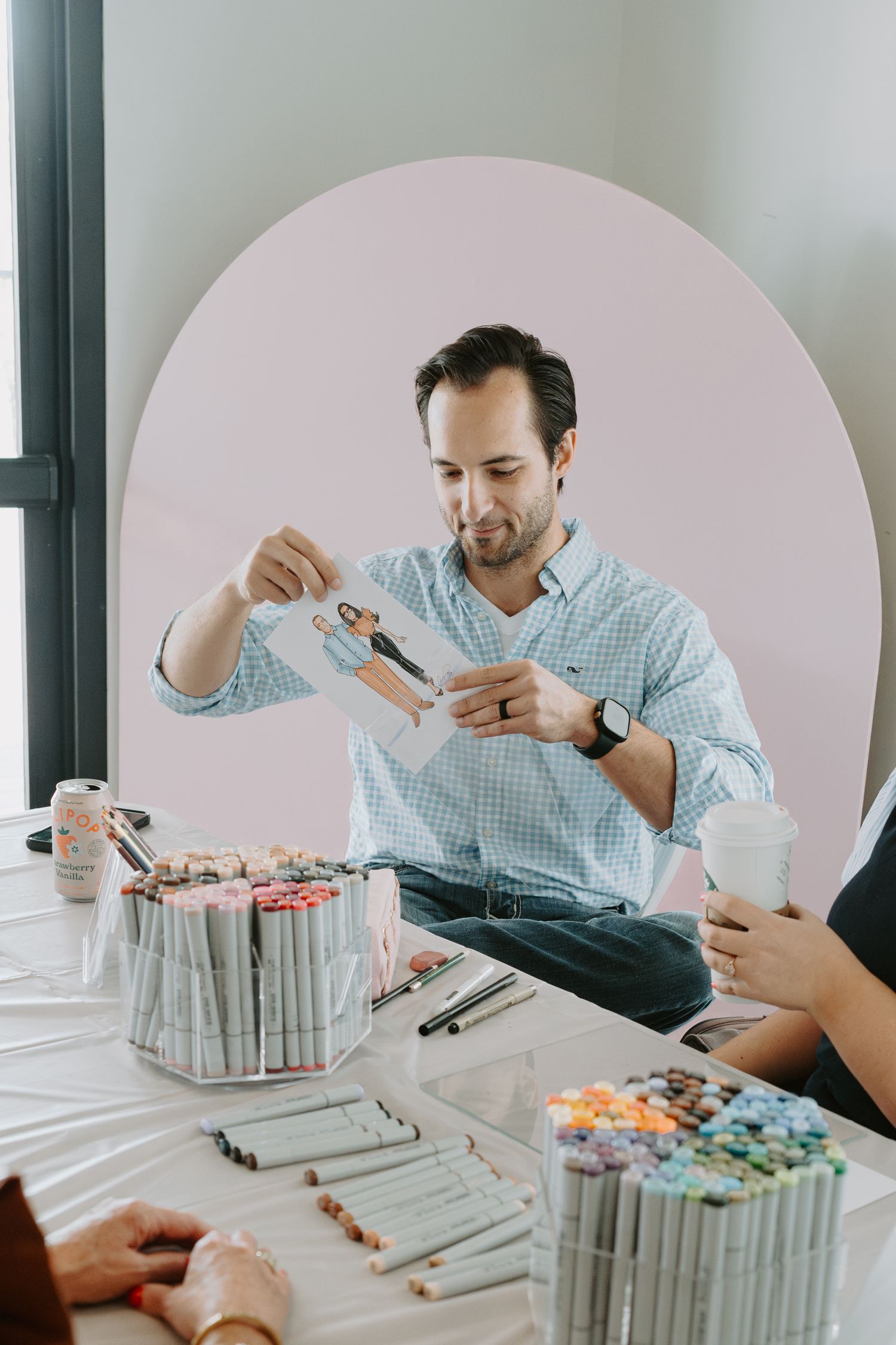 Person working with art supplies and materials on white table during creative activity.