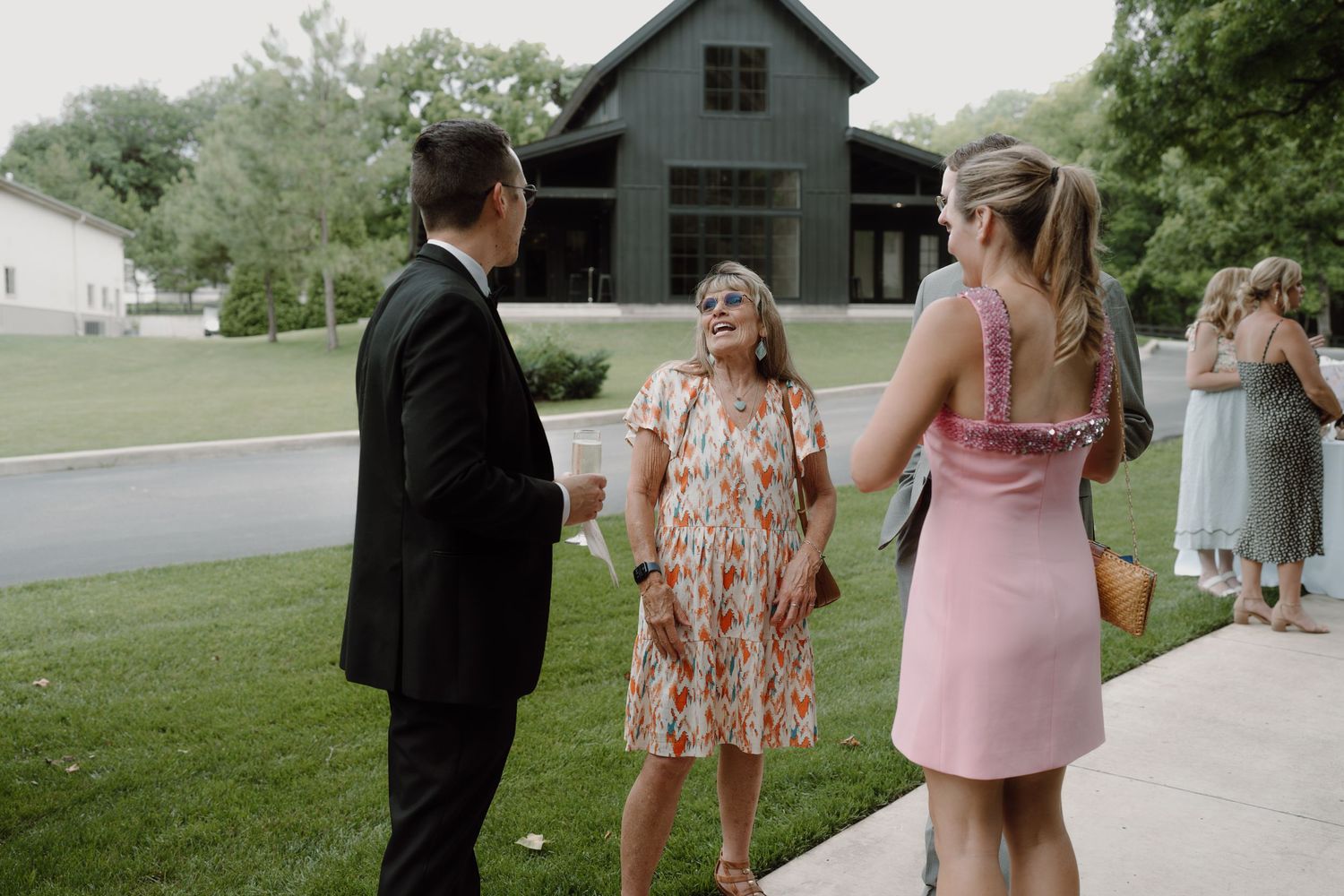 Wedding party walking together outside a rustic barn venue.