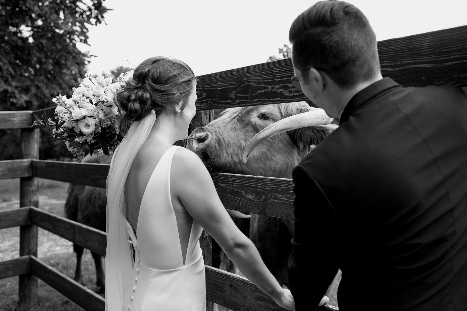 Intimate black and white wedding portraits captured along a wooden ranch fence.