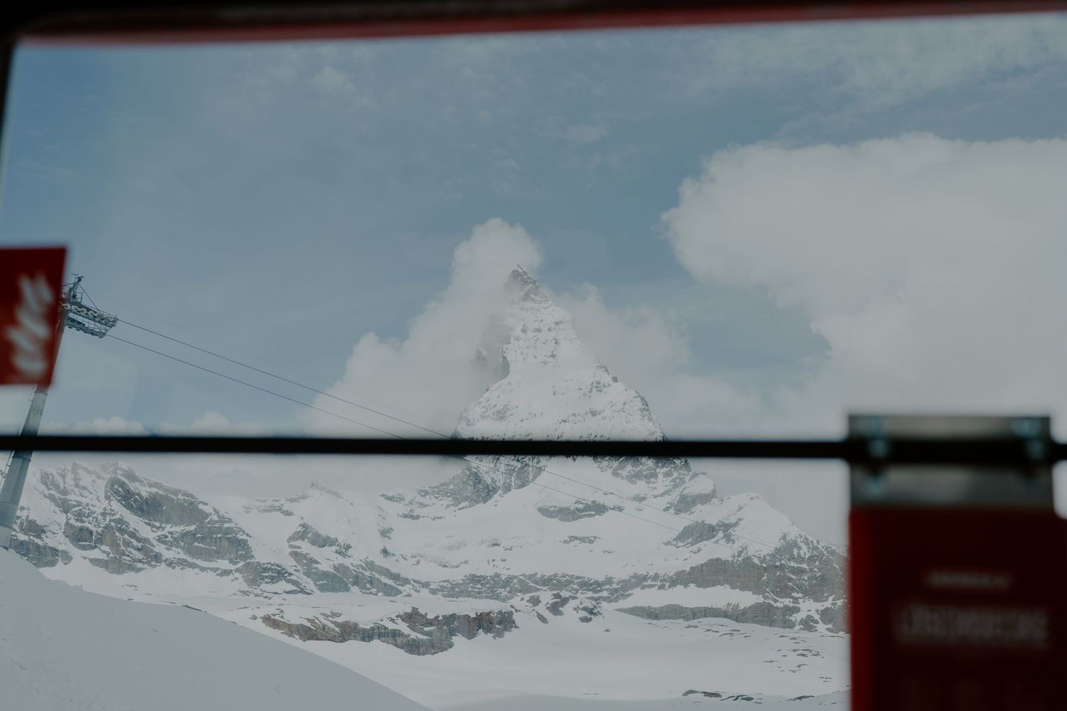 Snow-capped mountain peaks against cloudy sky in winter landscape.