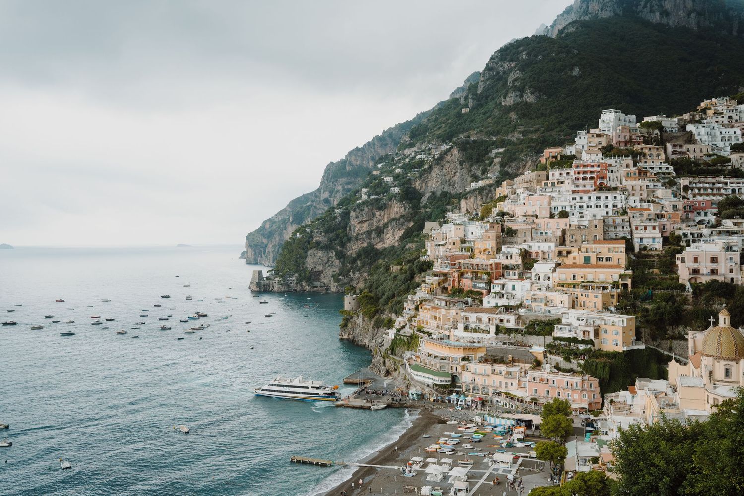 Panoramic view of the Amalfi Coast showing colorful buildings cascading down cliffs to the sea.