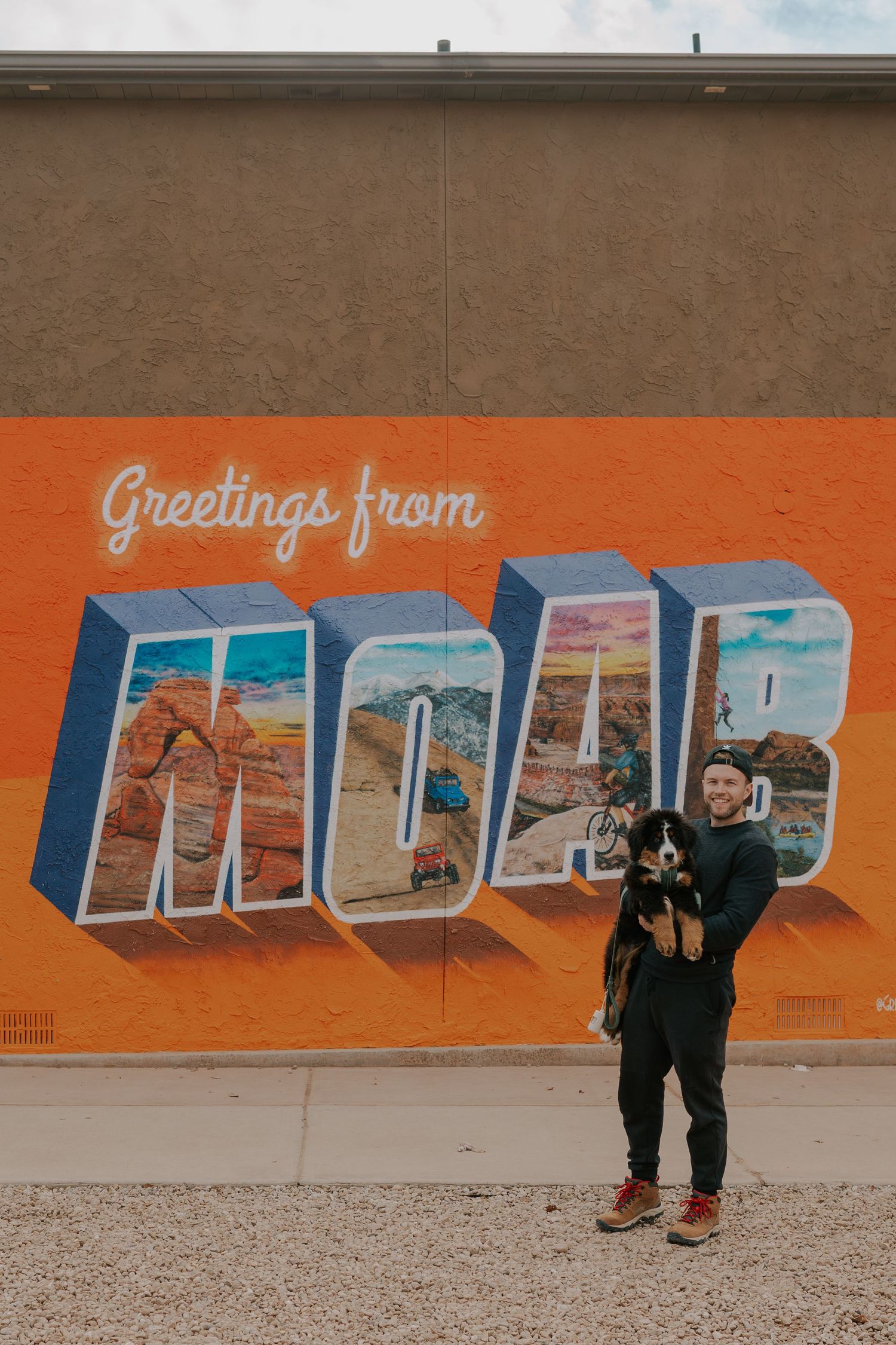 Colorful mural on orange wall features retro-style block letters spelling out a destination greeting.