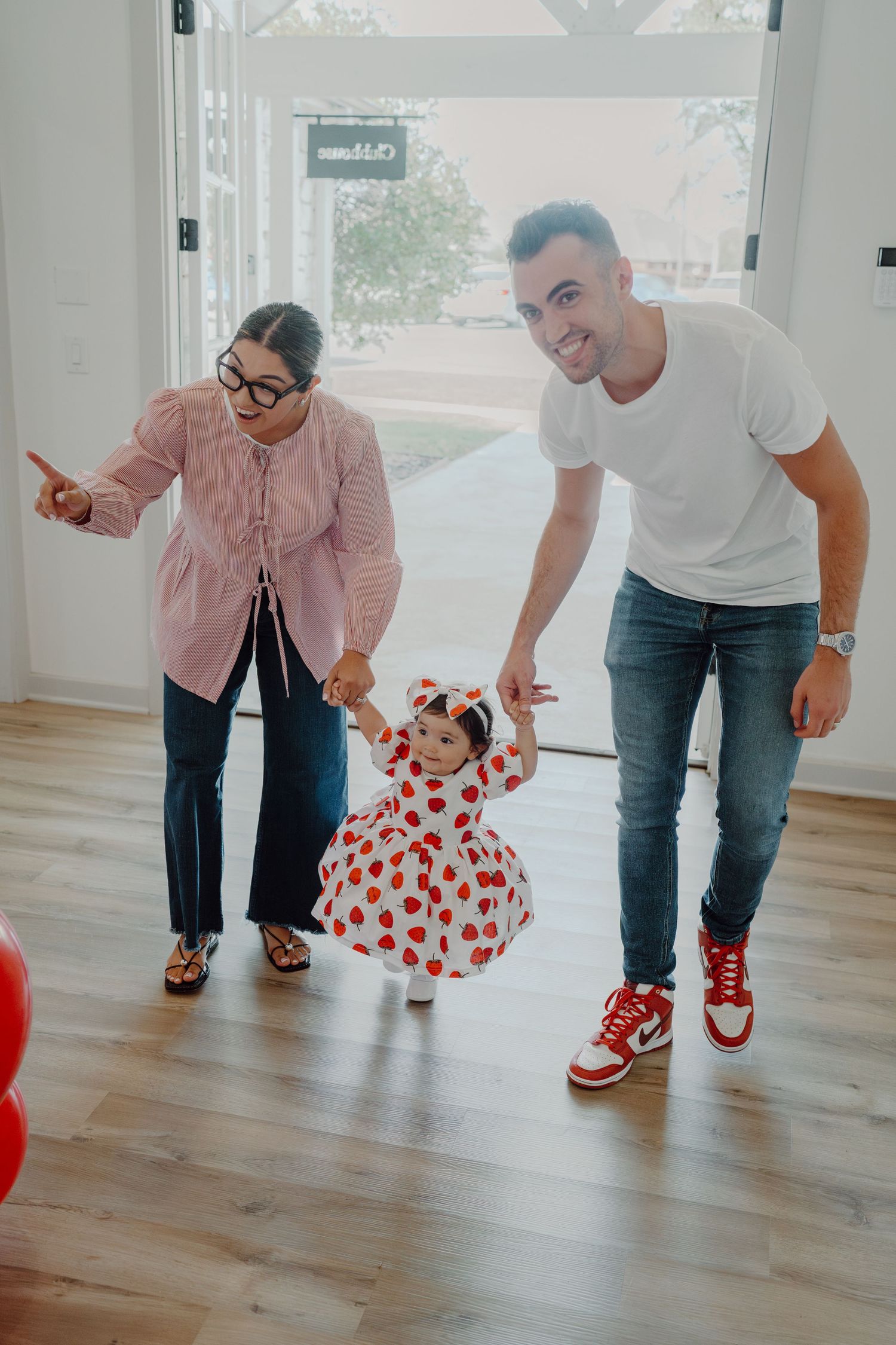 Playful scene with people bending down in coordinated poses on a hardwood floor.
