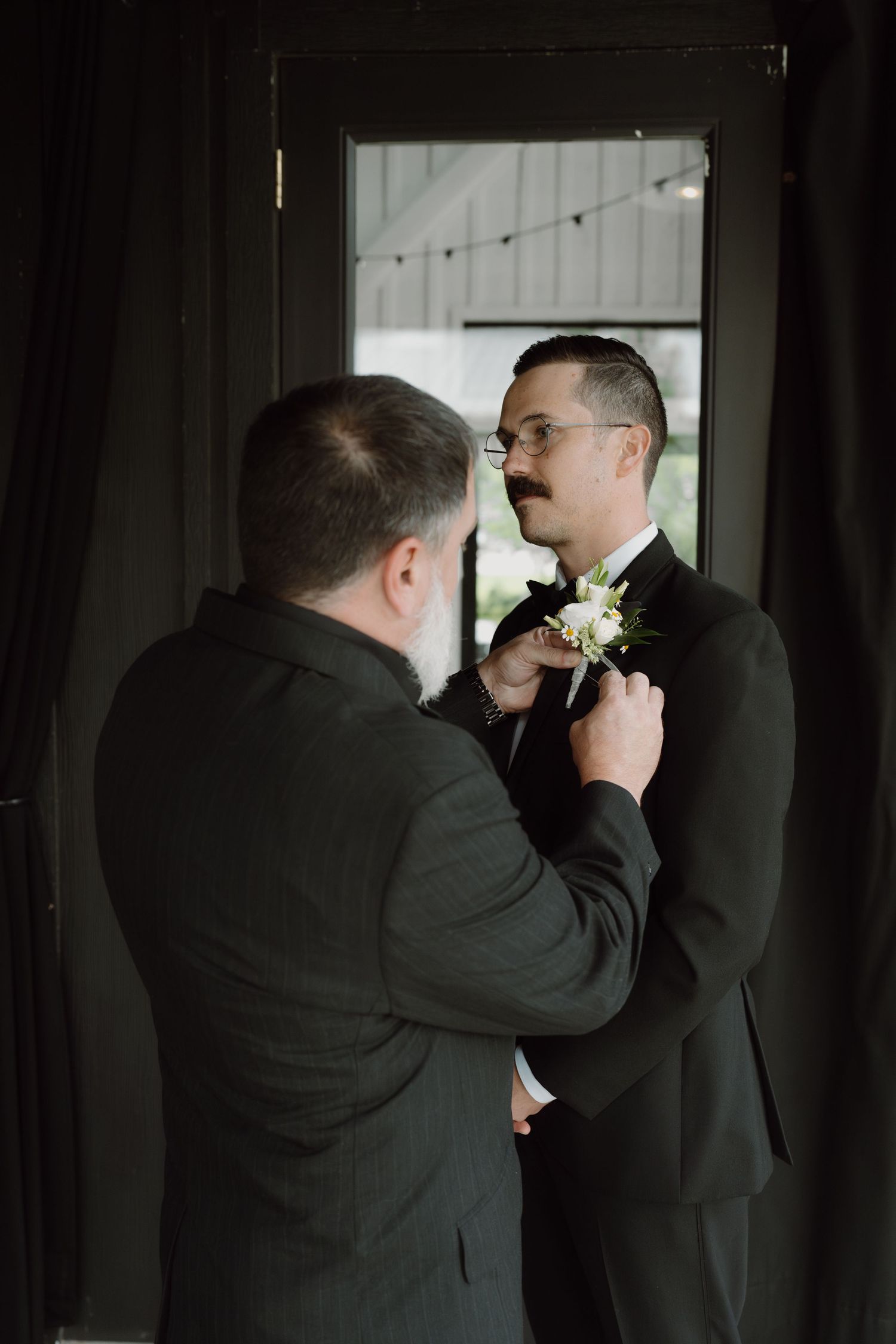 A series of images showing formal attire adjustments in a dimly lit room.