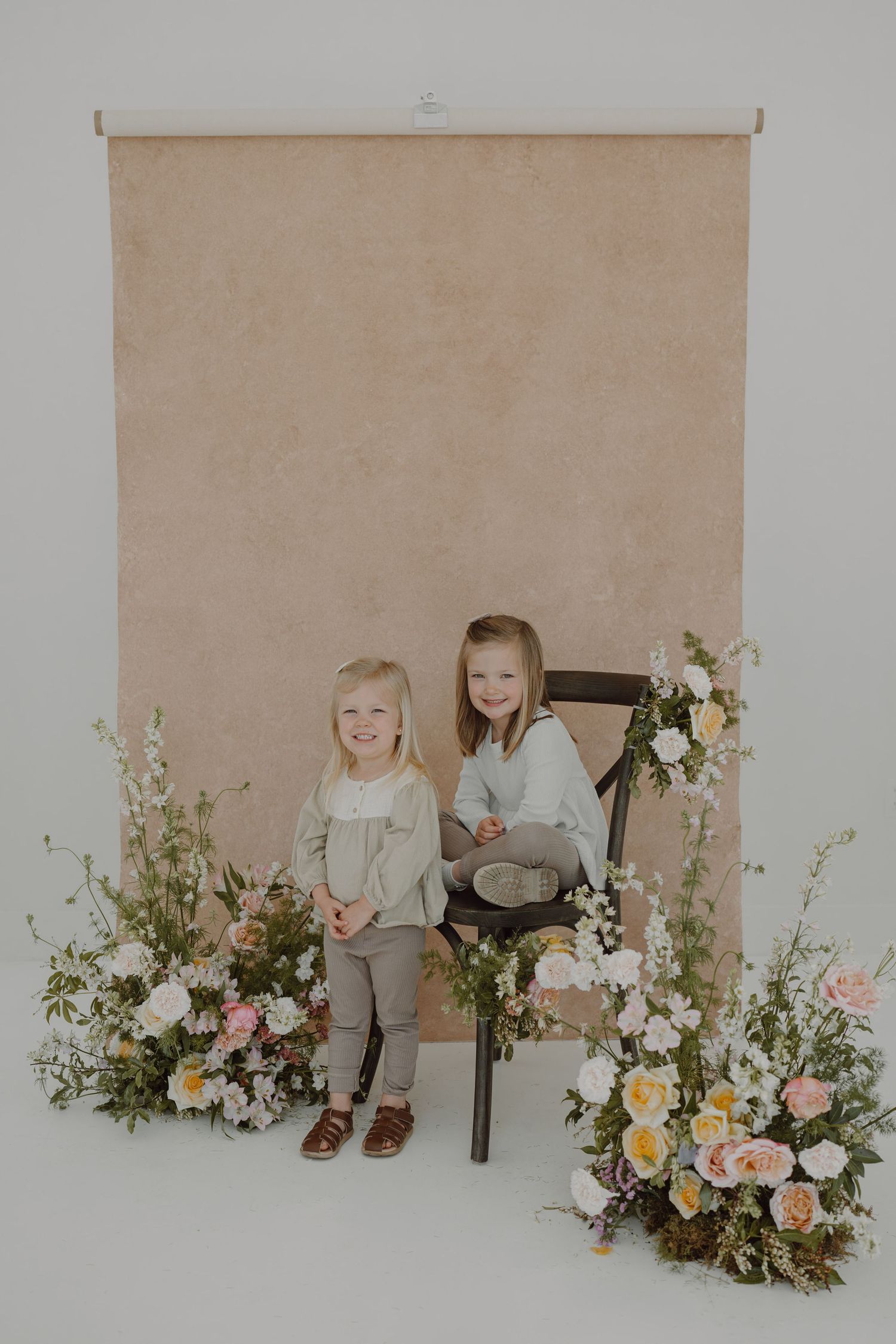 Professional photo studio arrangement with spring flowers and vintage chair.