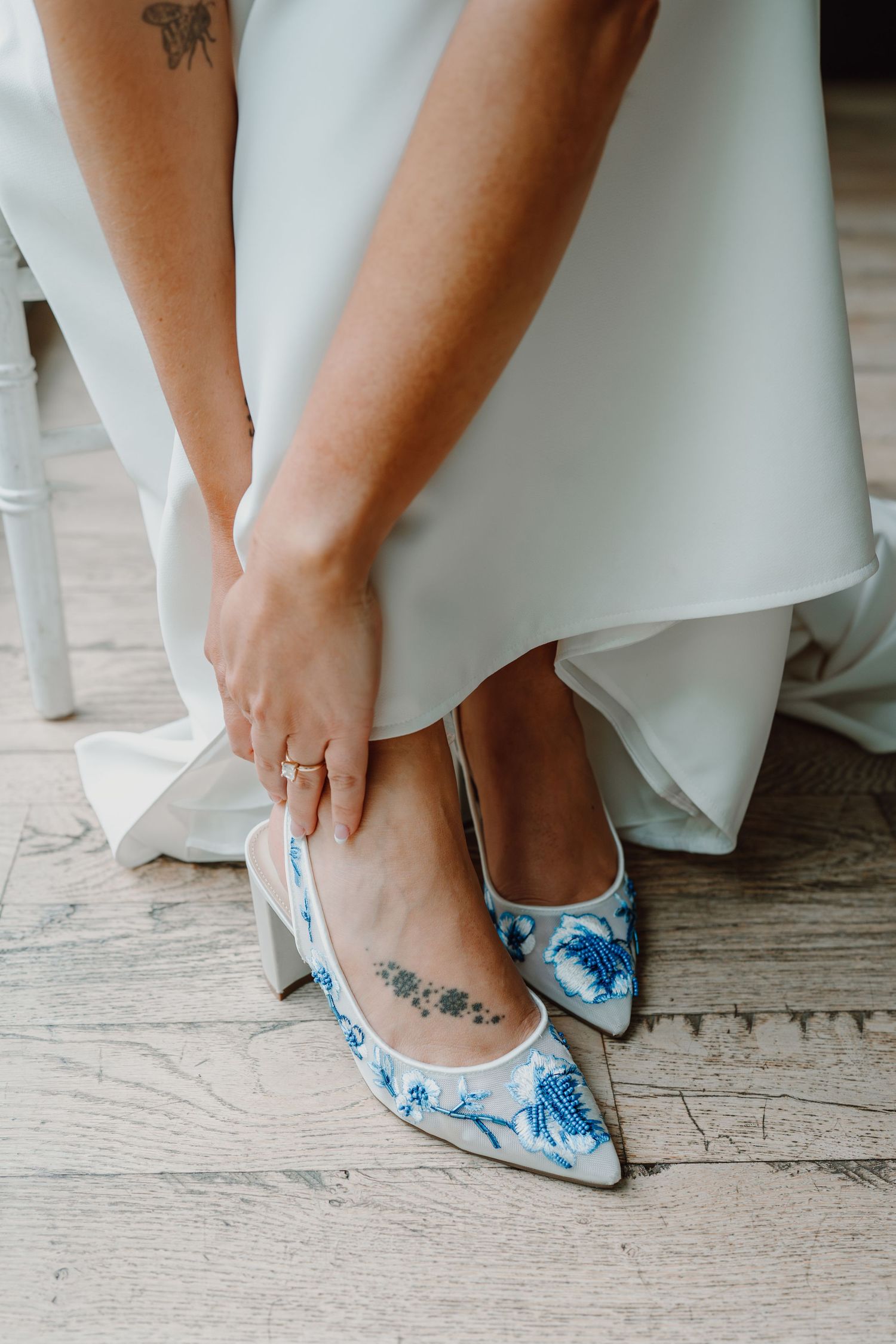 Close-up of blue and white floral wedding shoes with delicate details.