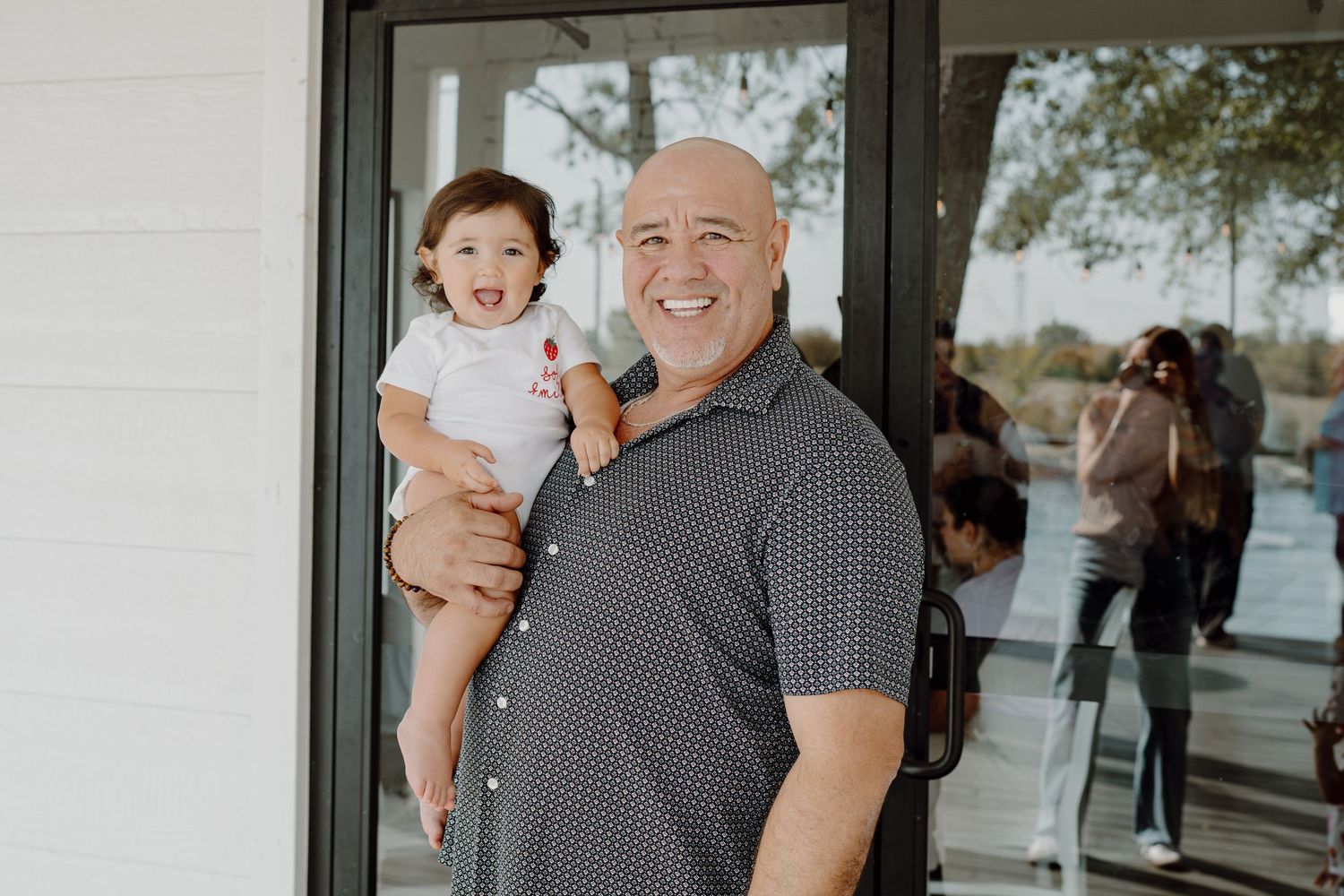 Outdoor portraits taken in front of a white building with glass doors.