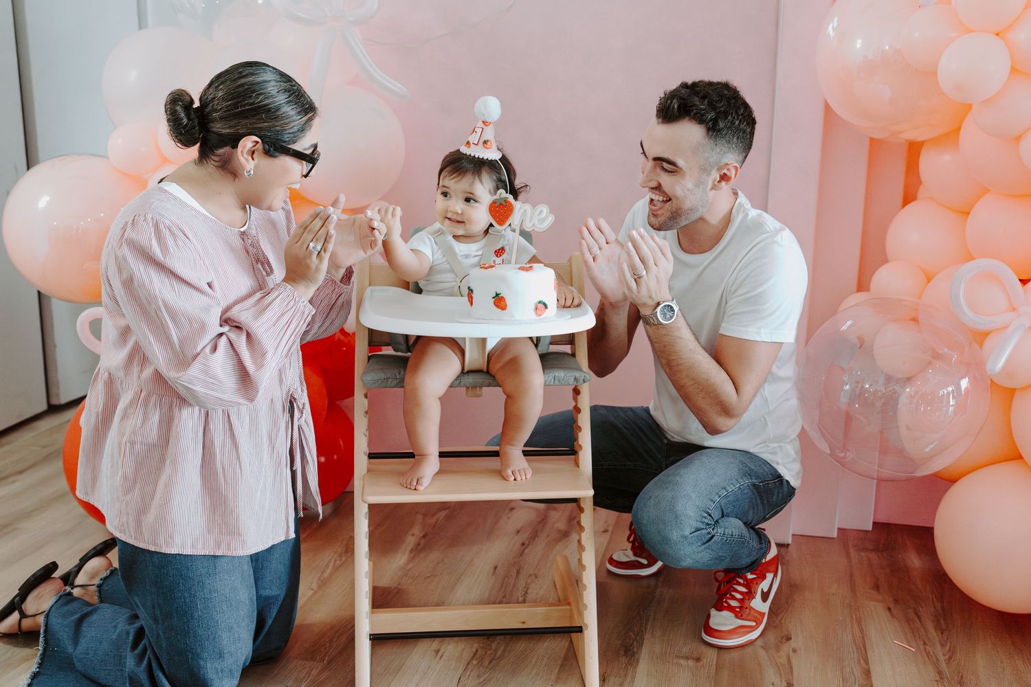 Pink-themed birthday celebration with balloon decorations and neon lighting.