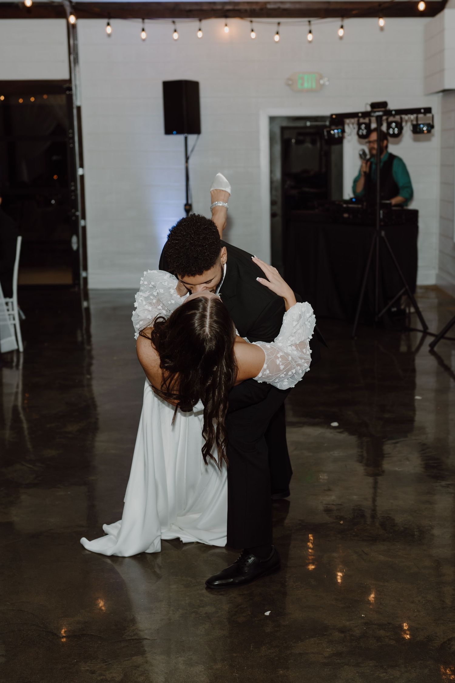 A dramatic dip during the wedding dance on a polished concrete floor with candlelight.