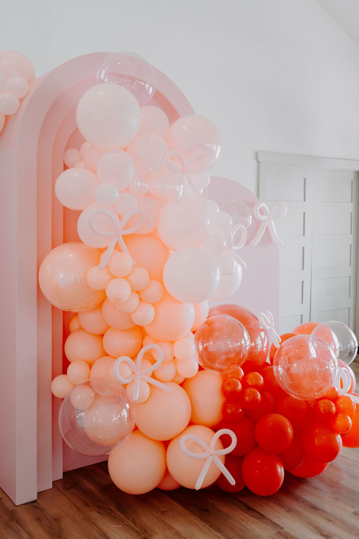 Large balloon installation featuring white and red balloons with bow designs.