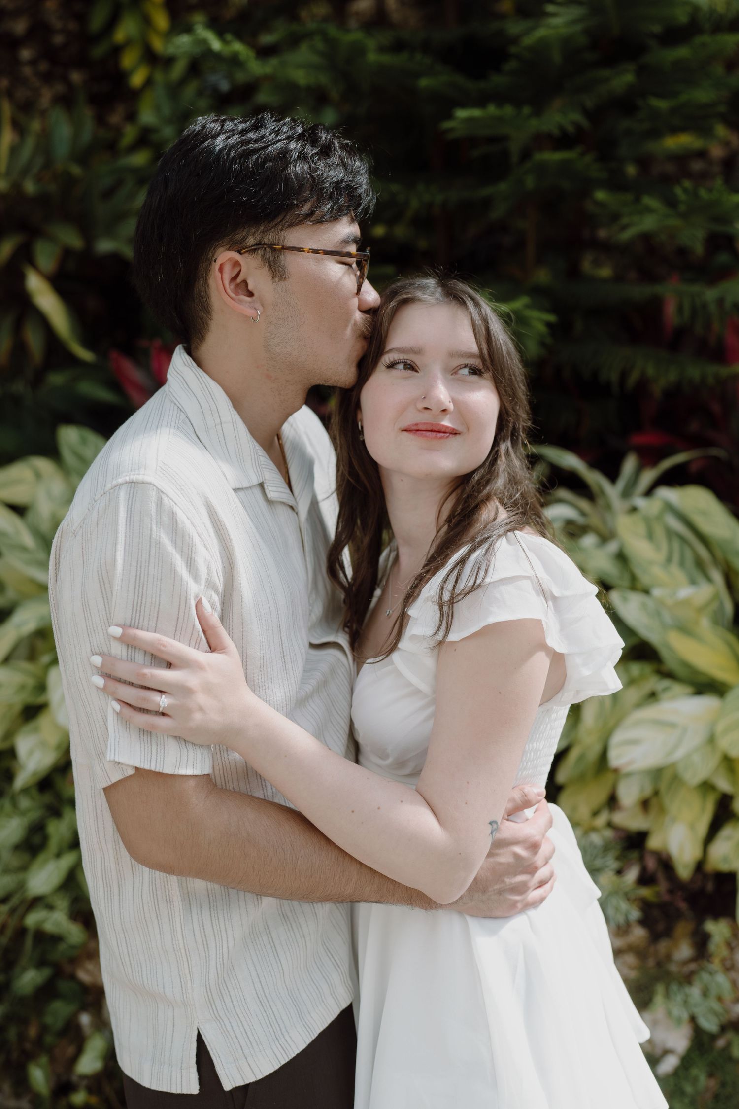 A tender embrace captured against a backdrop of green garden foliage.