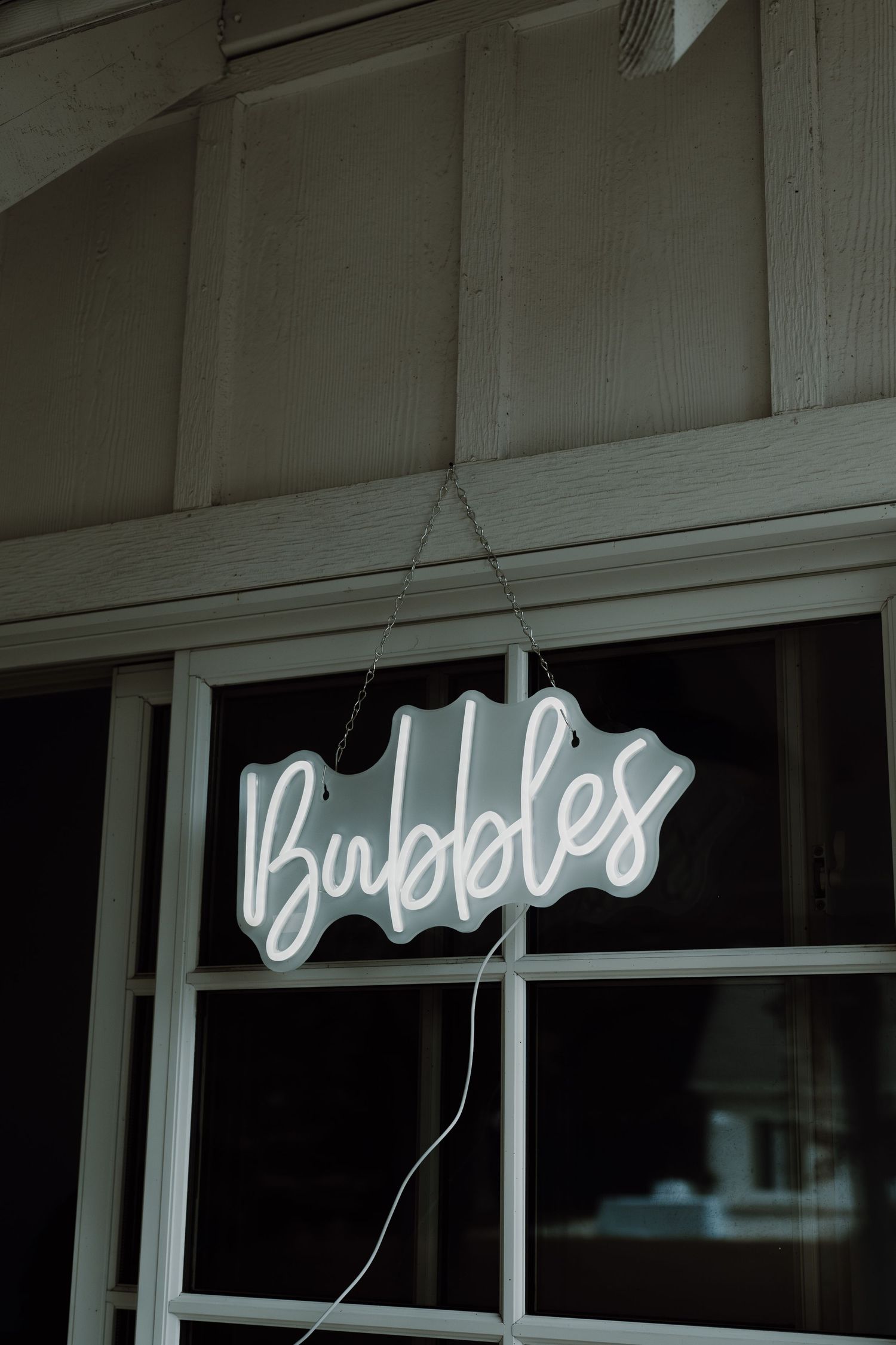 Neon sign text mounted on a white building exterior.