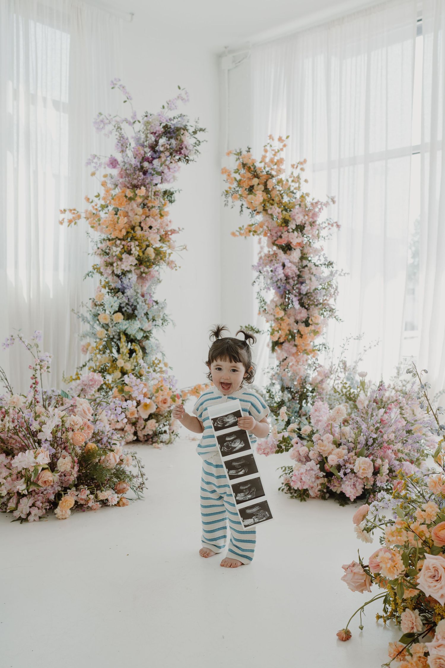 Studio photography setup with ultrasound photos and delicate floral decorations.
