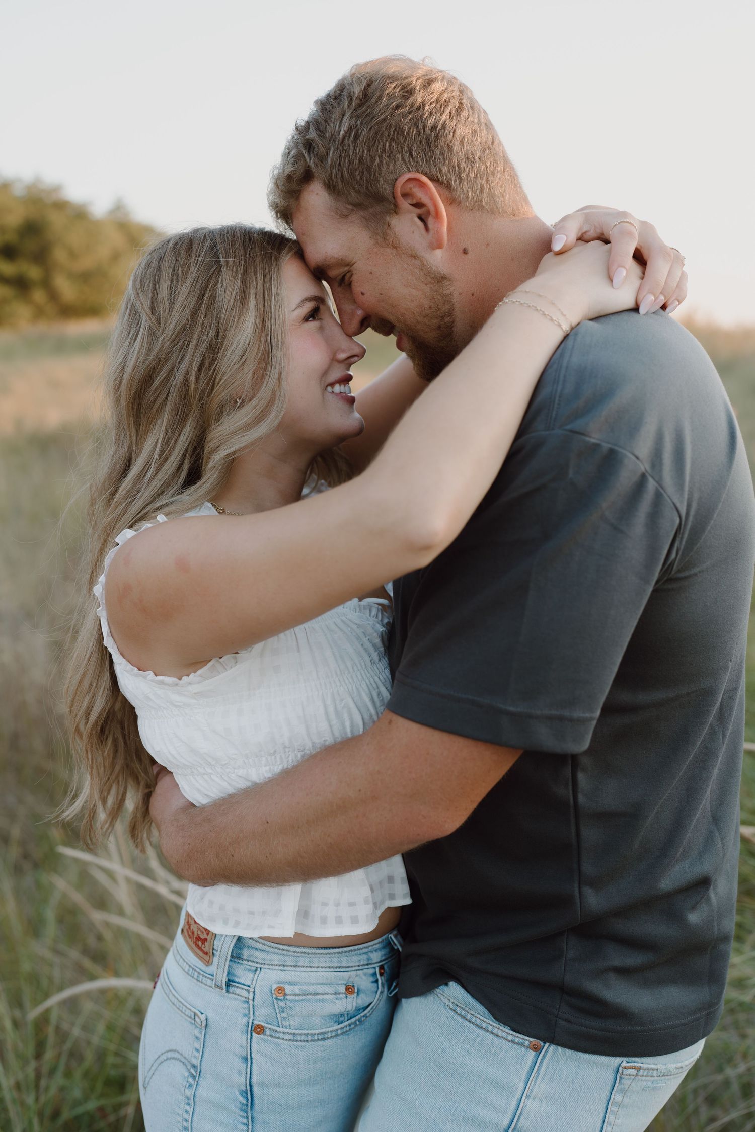 Romantic couple sharing an intimate moment while standing together on sandy dunes.