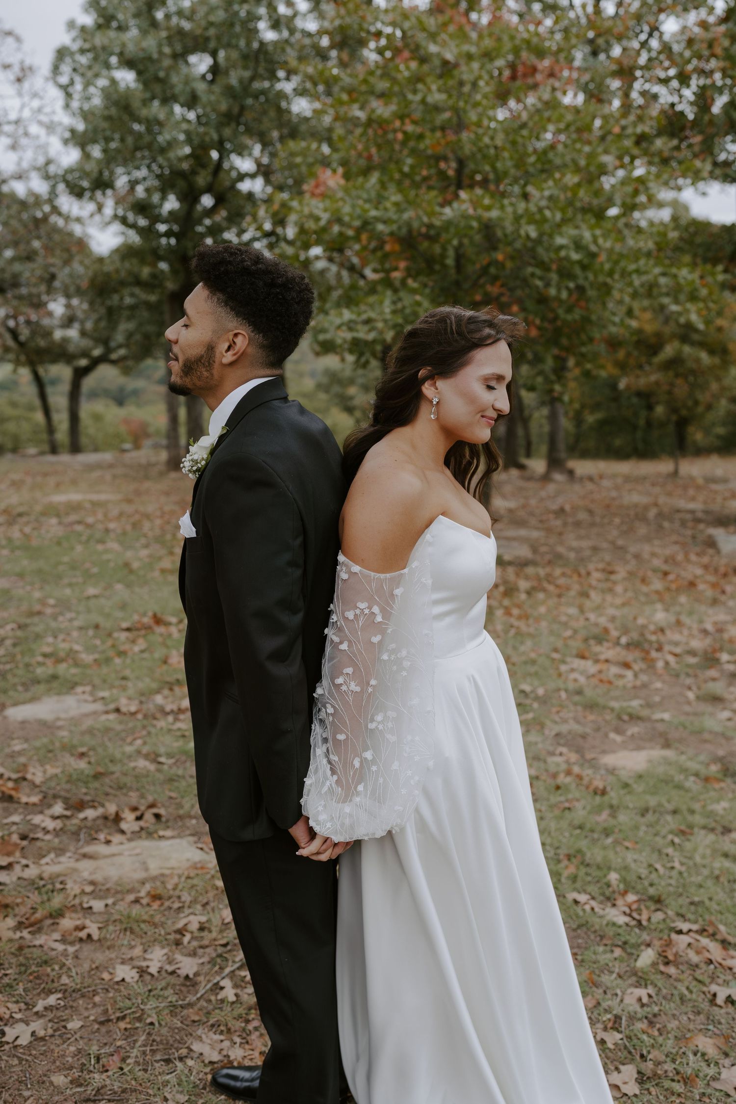 A couple shares their first look moment in a rustic outdoor setting.