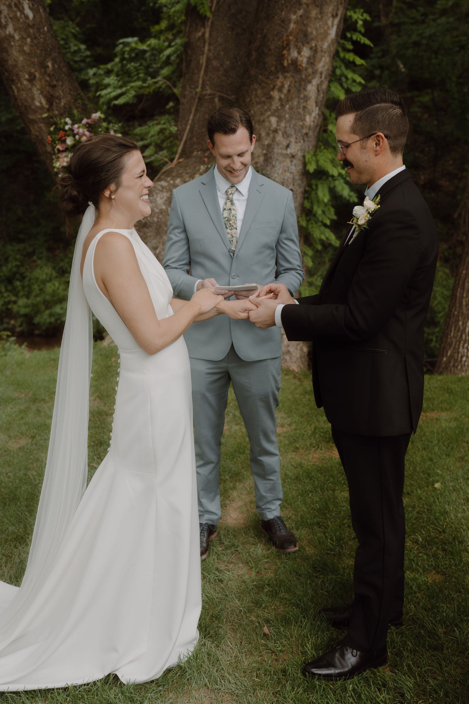 Wedding ceremony sequence showing exchange of rings in an outdoor woodland setting.