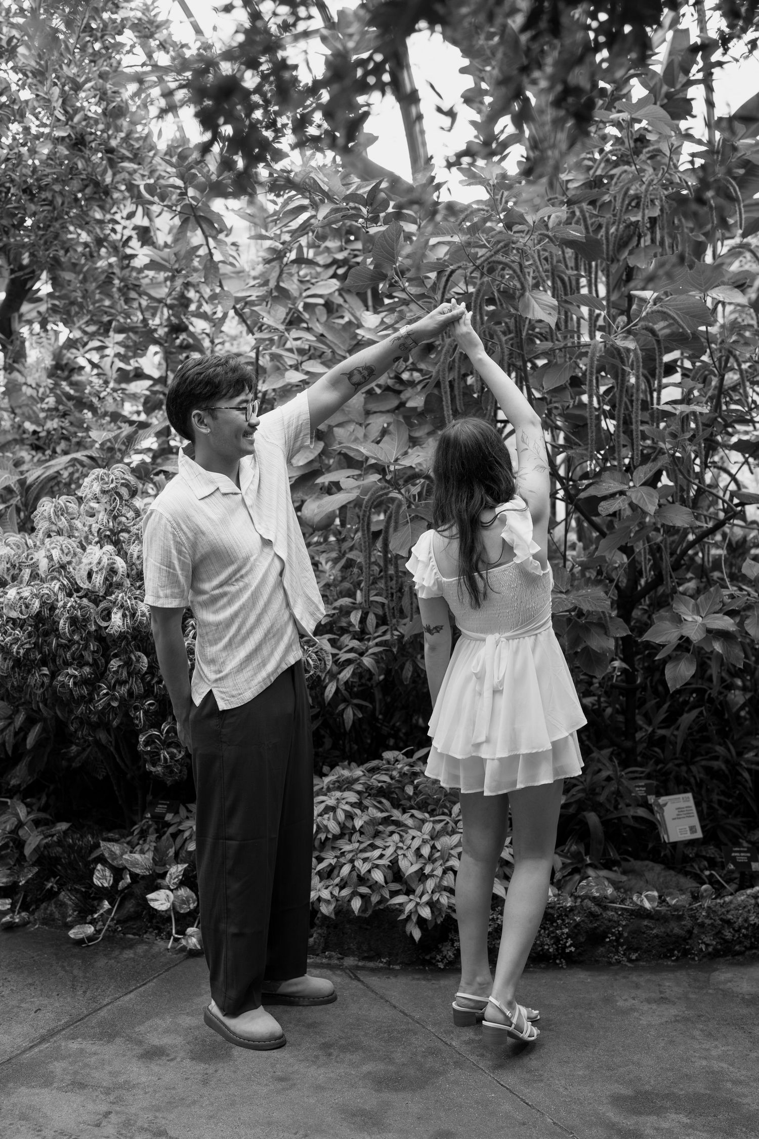 Black and white sequence of a couple dancing and embracing in a garden.