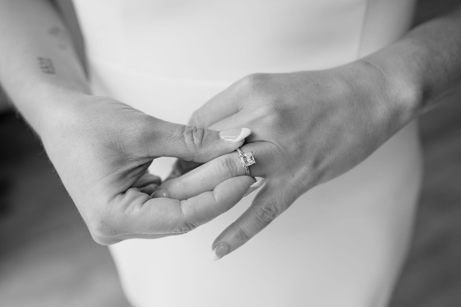 Close-up detail shot of hands and rings during a wedding preparation moment.