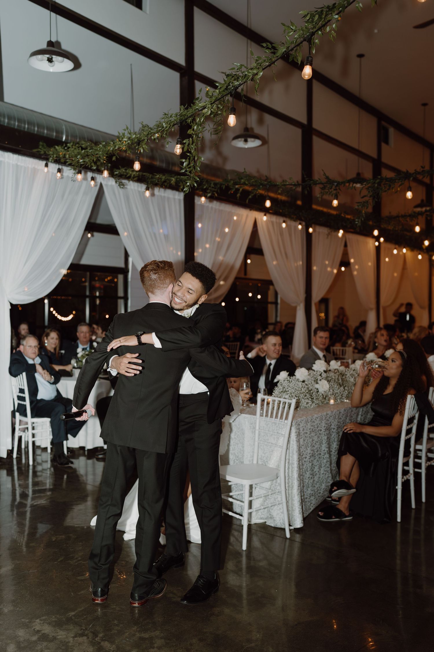 Wedding guests performing a synchronized dance routine on a polished concrete floor.