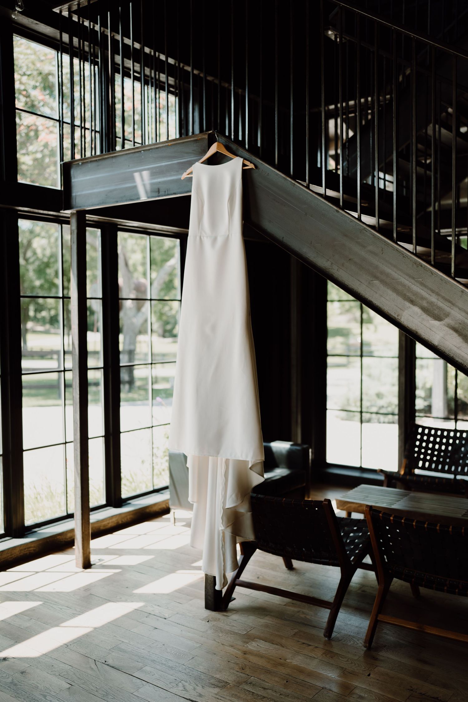 Modern interior with natural light streaming through floor-to-ceiling windows onto wooden flooring.