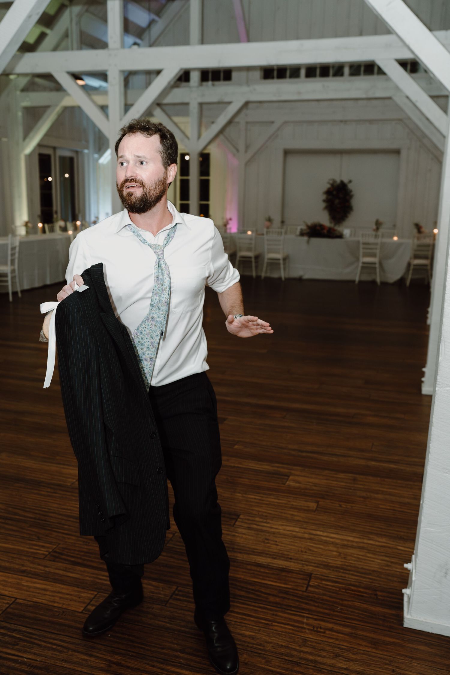 Guest dancing solo at a wedding reception in a white shirt and tie.