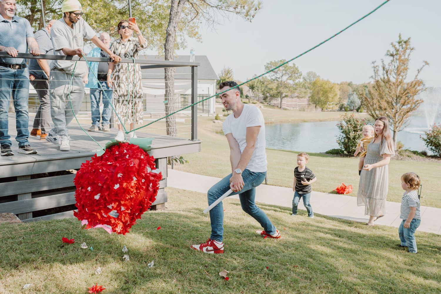 Red decorative items scattered across a lawn as people gather them up.