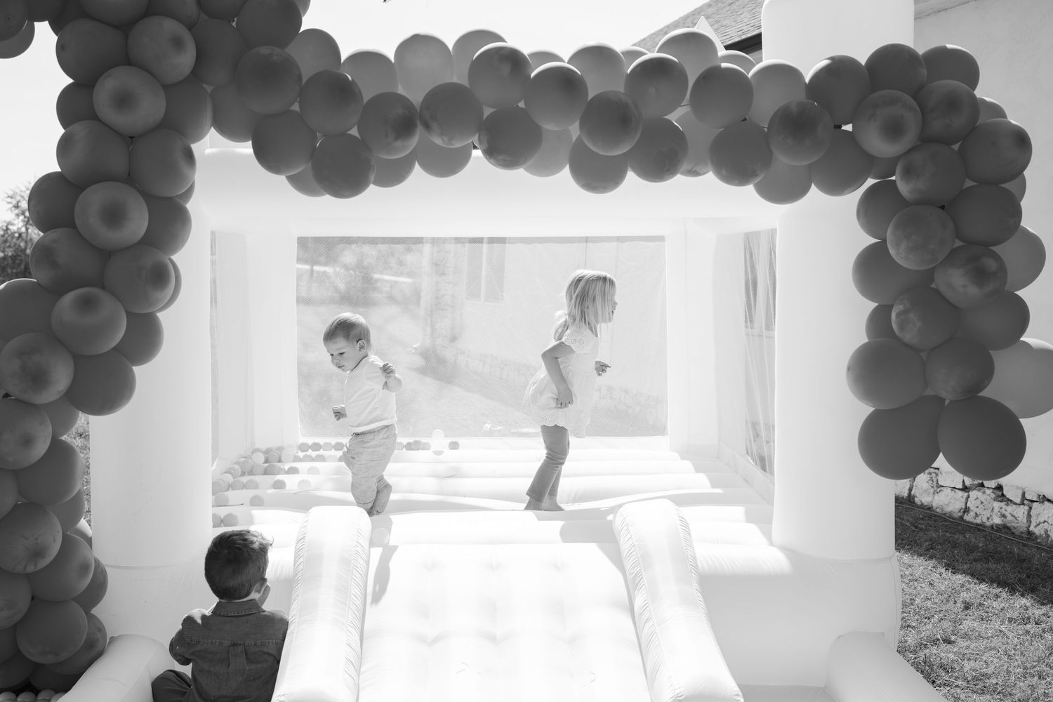 White room decorated with black balloon arches and garlands for a celebration.