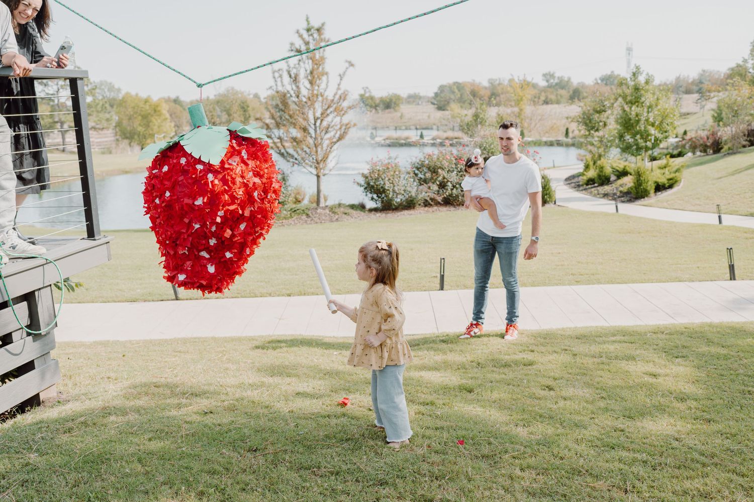 A green string stretches across an outdoor scene with people and a red heart balloon visible.