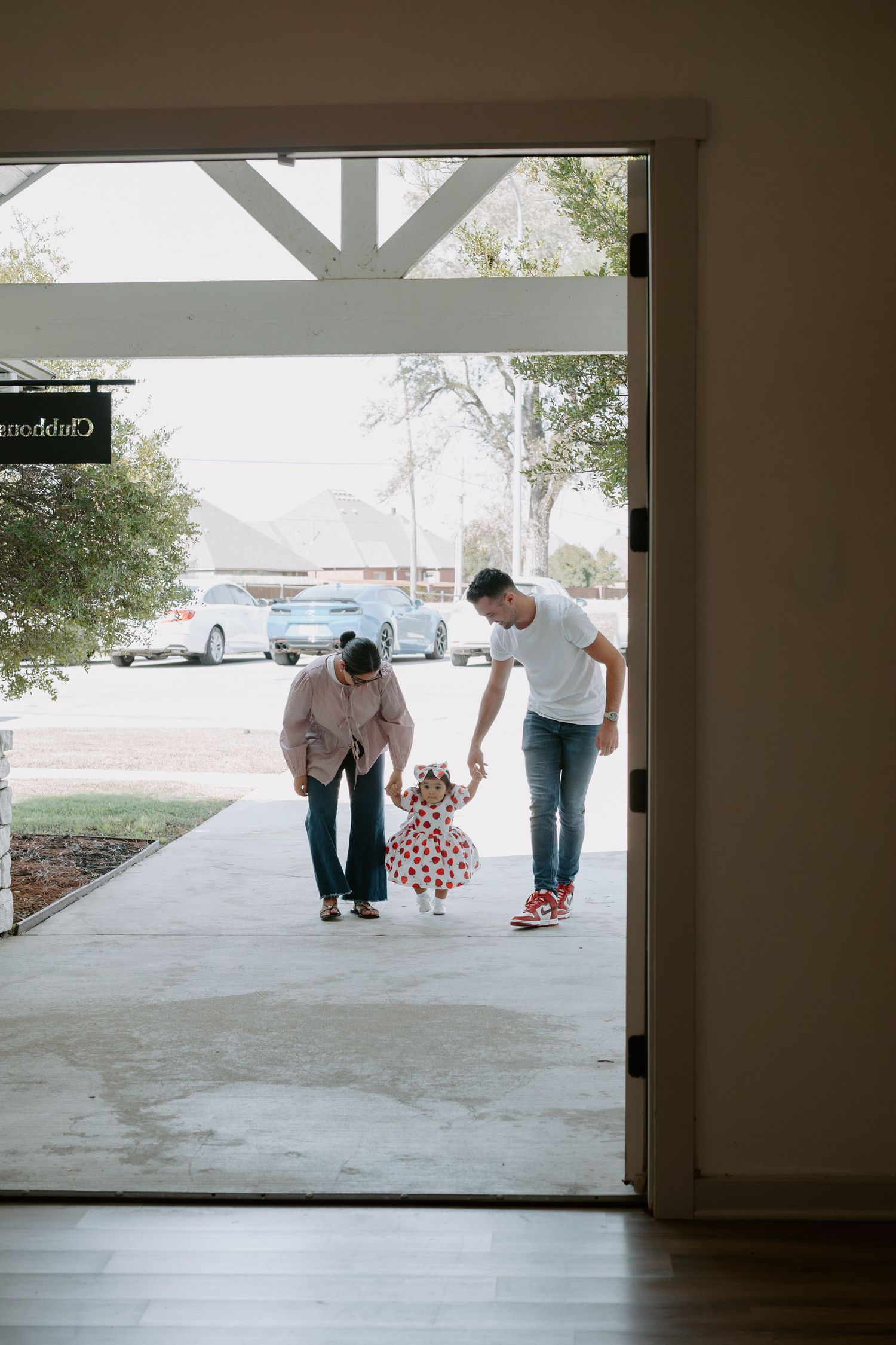 View through large glass doors showing people on an outdoor patio.