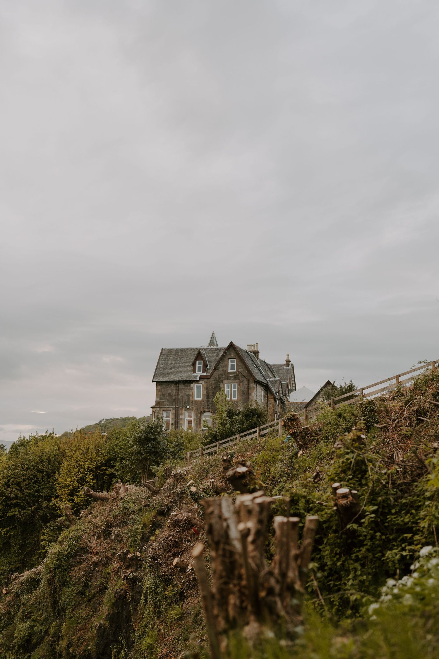 Gothic stone houses perched dramatically on a rugged cliff overlooking the sea.
