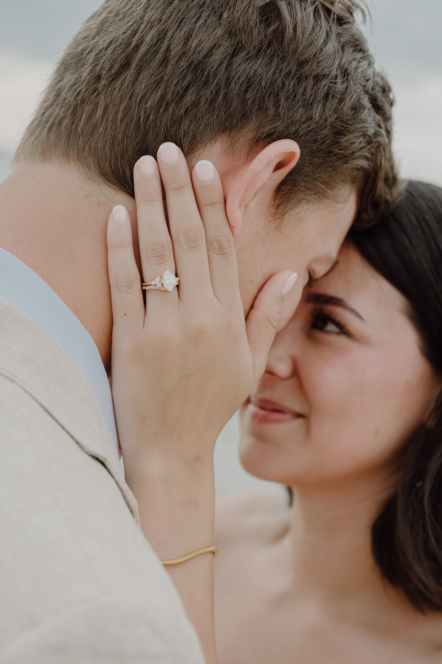 Intimate romantic moment between couple with engagement ring visible.
