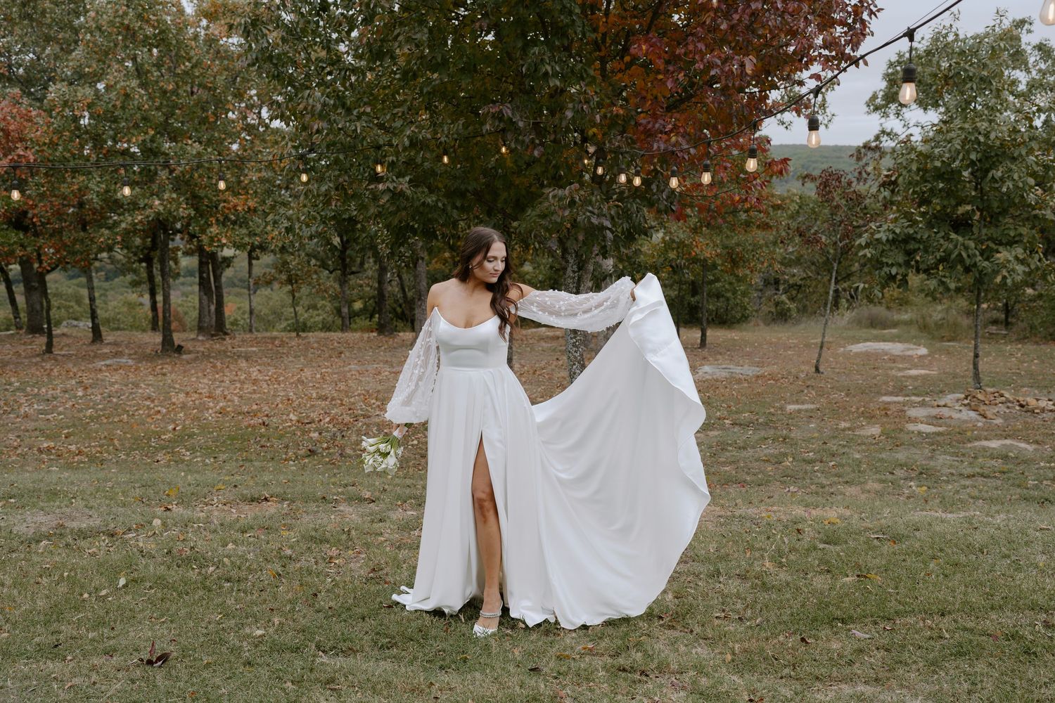 Elegant white wedding dresses photographed in motion against fall foliage backdrop.