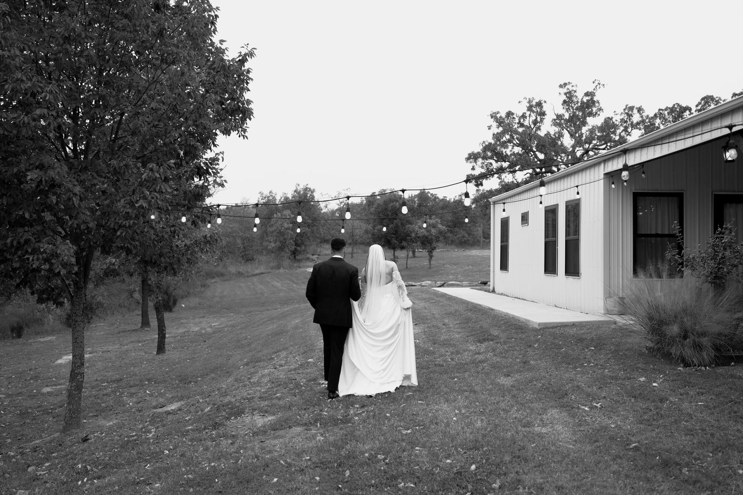 Black and white panoramic view of an outdoor wedding ceremony setup with chairs on a hillside.
