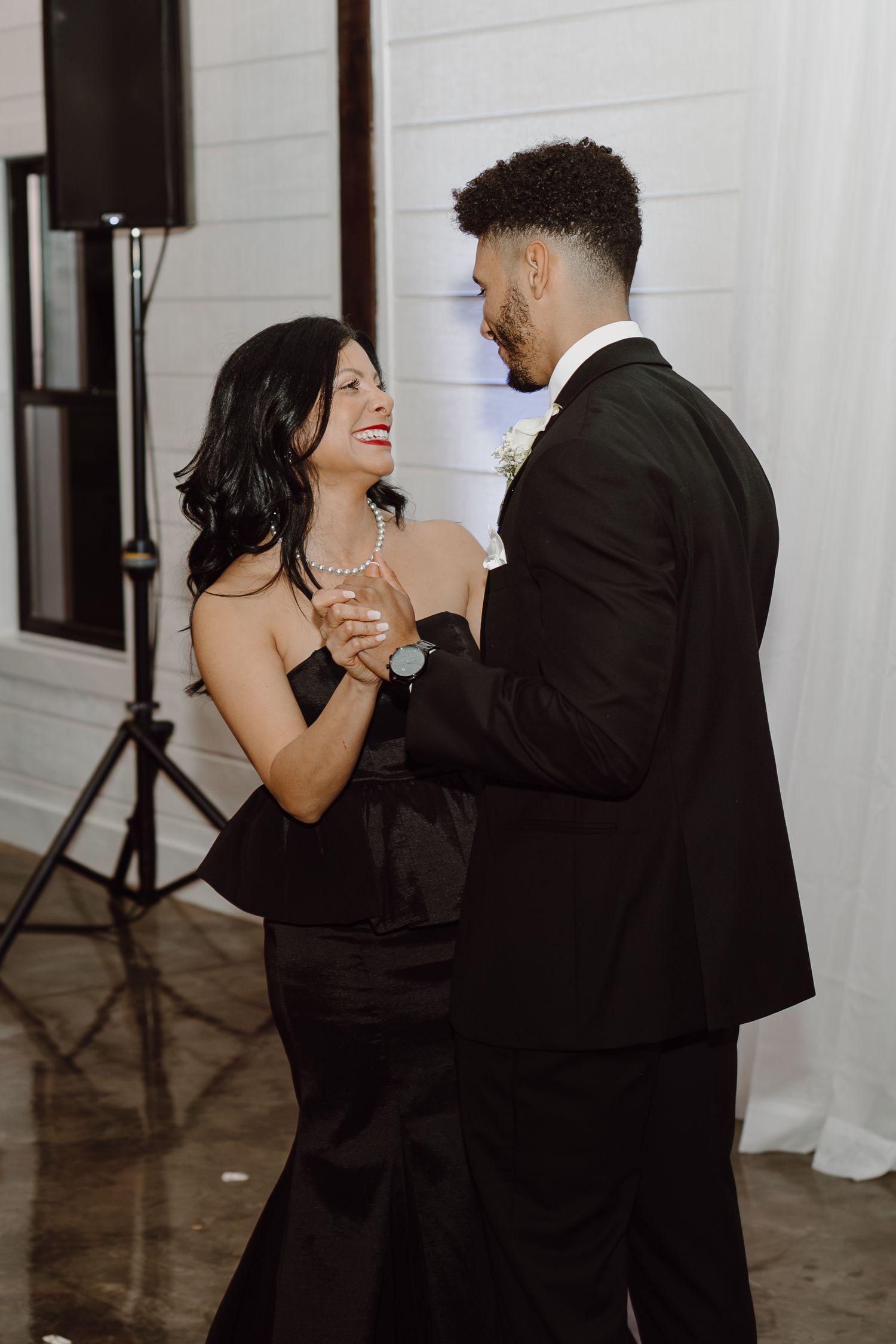 Couples dancing together during a romantic moment at an indoor wedding reception.