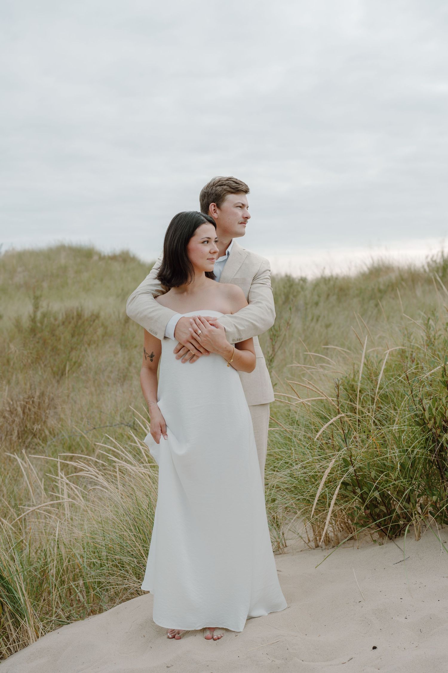 Joyful couple sharing intimate moments during their coastal wedding photo shoot.