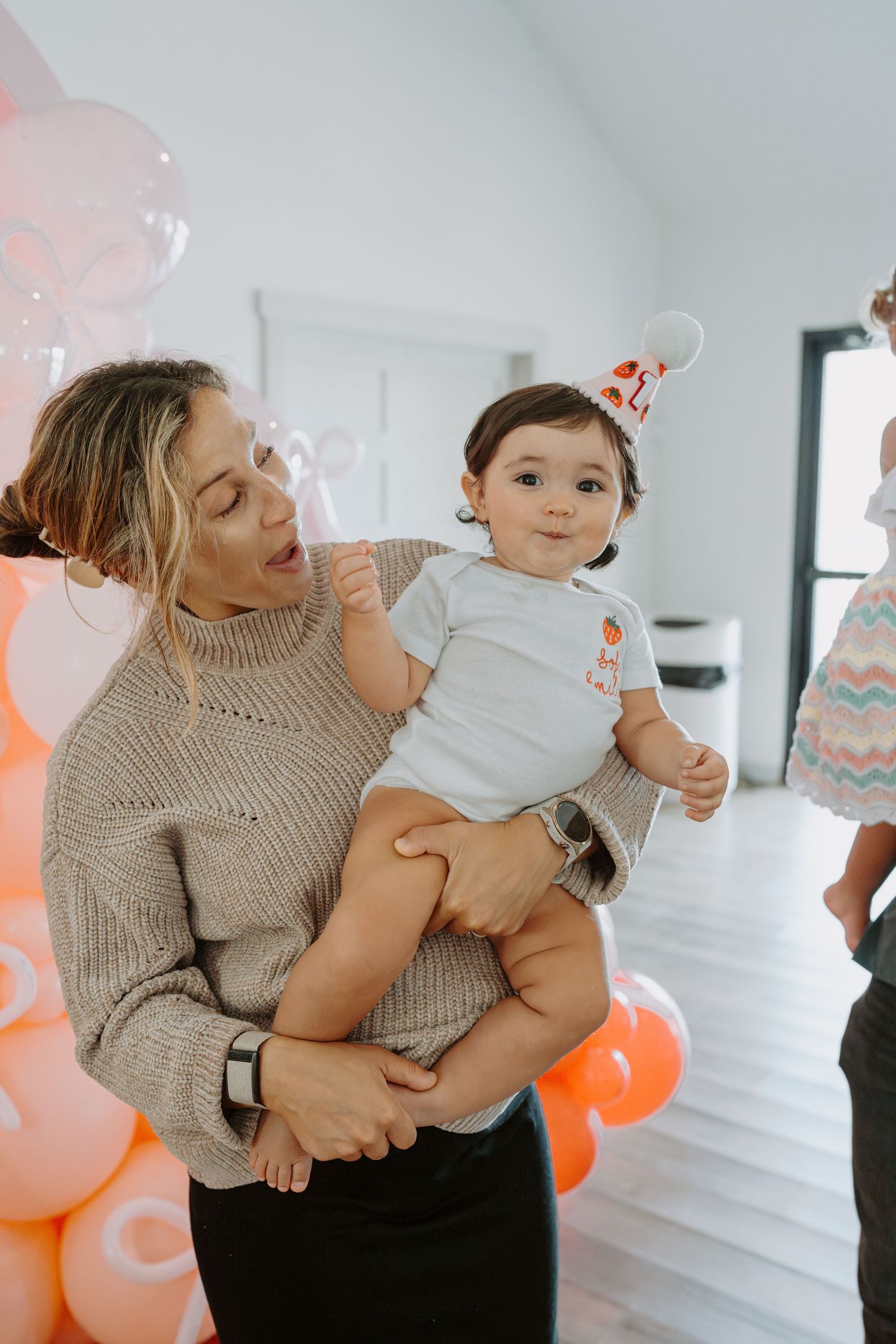 Candid moments captured during a celebration with peach balloon decorations.