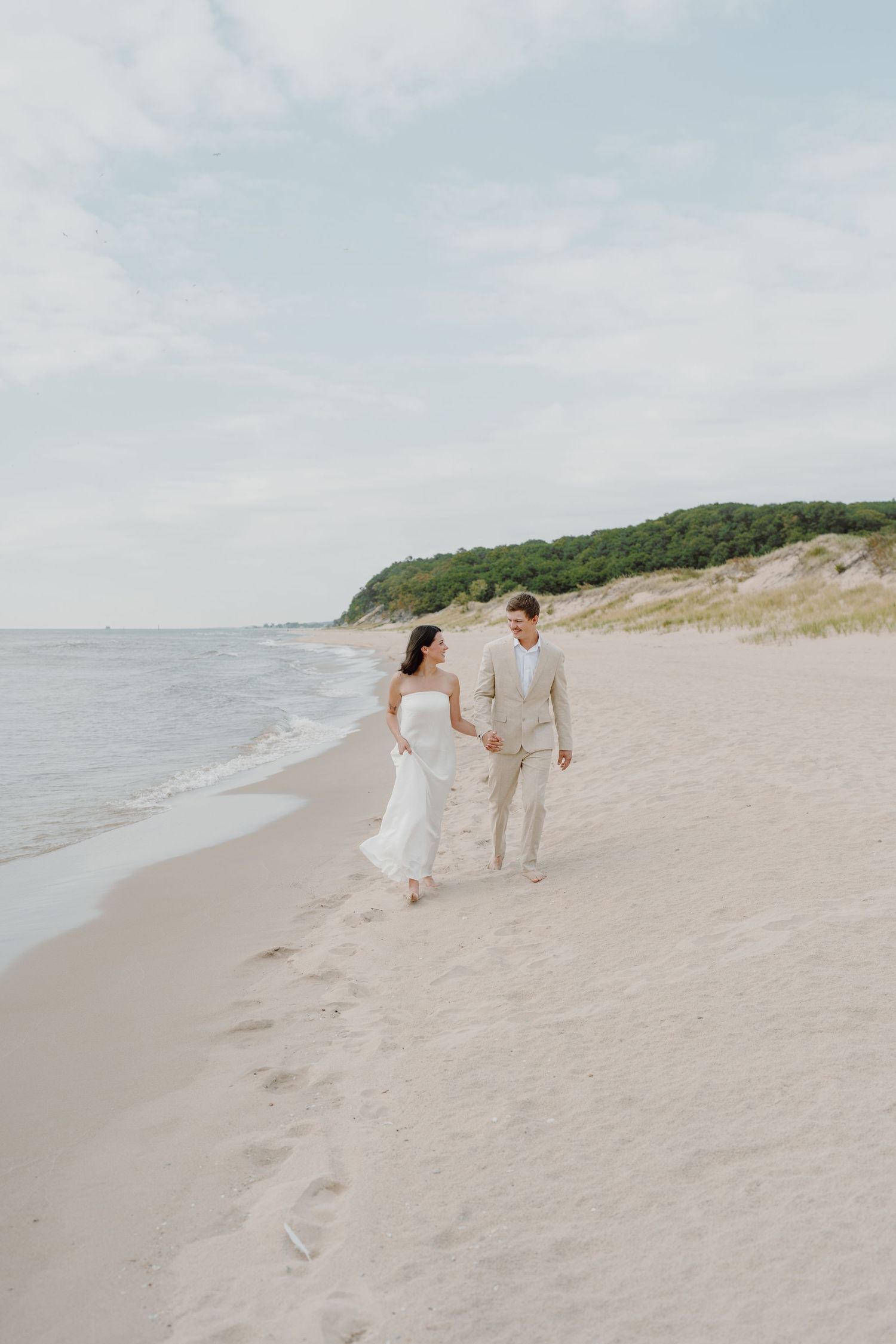 Couple enjoying a peaceful moment together on a sandy beach under cloudy skies.